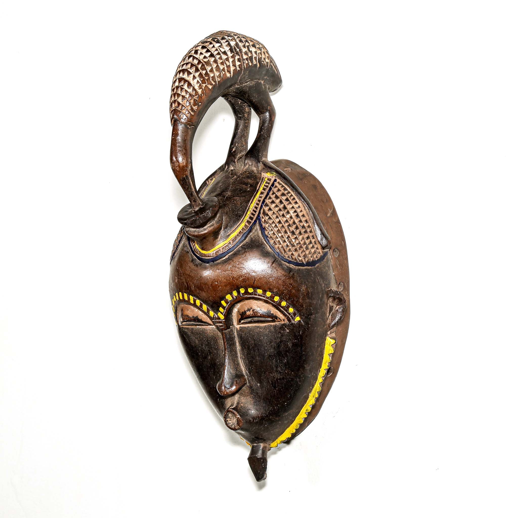 brown ceremonial African mask with intricate yellow painted designs for Sale