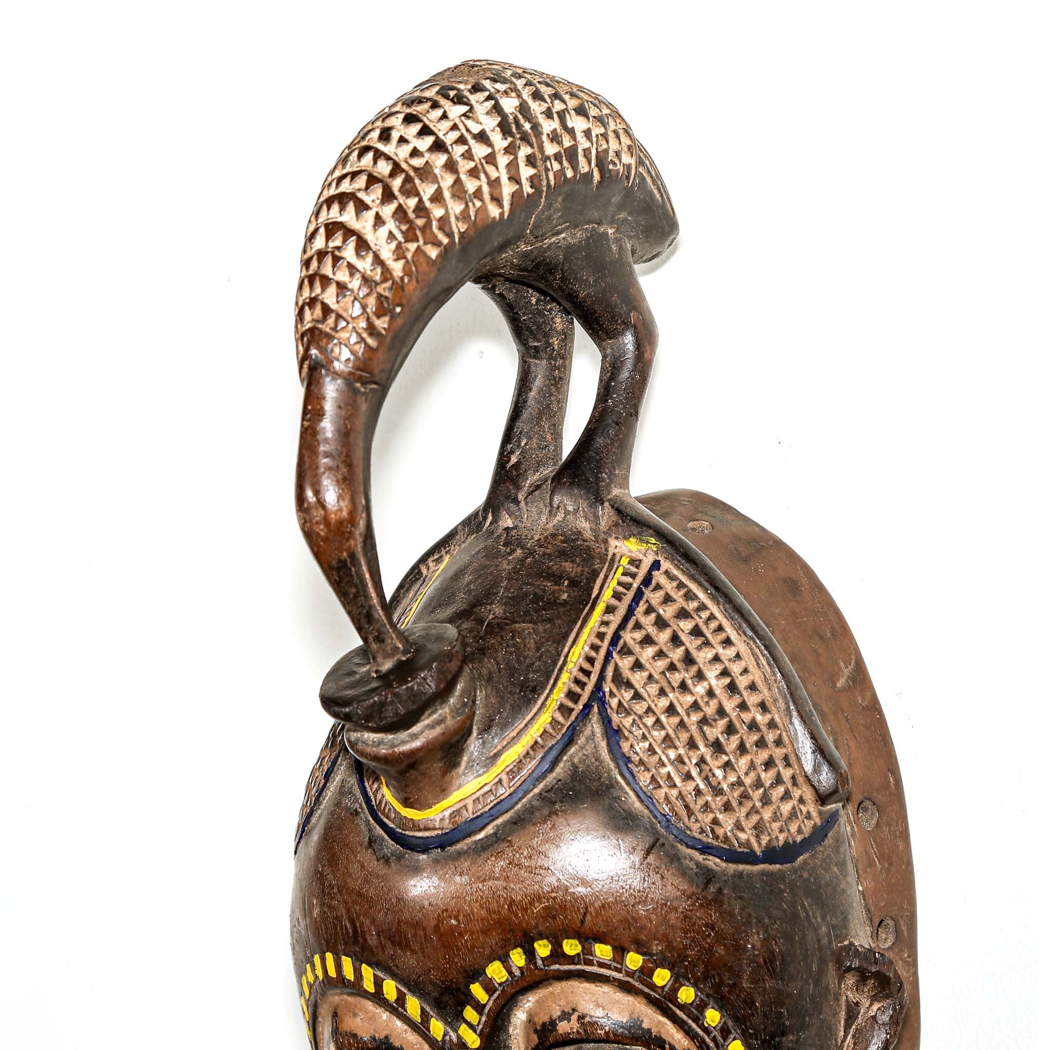 brown ceremonial African mask with intricate yellow painted designs for Sale