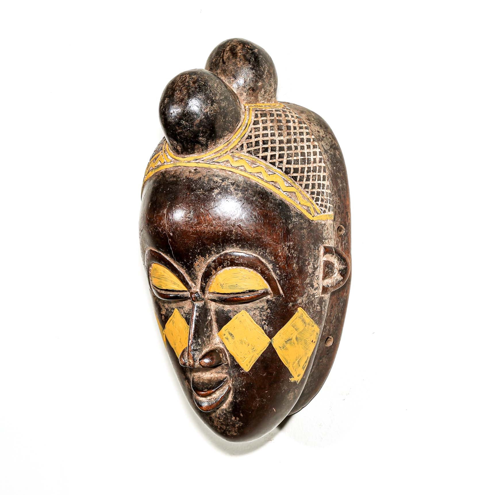 Wooden traditional African mask with yellow accents on a white background for sale