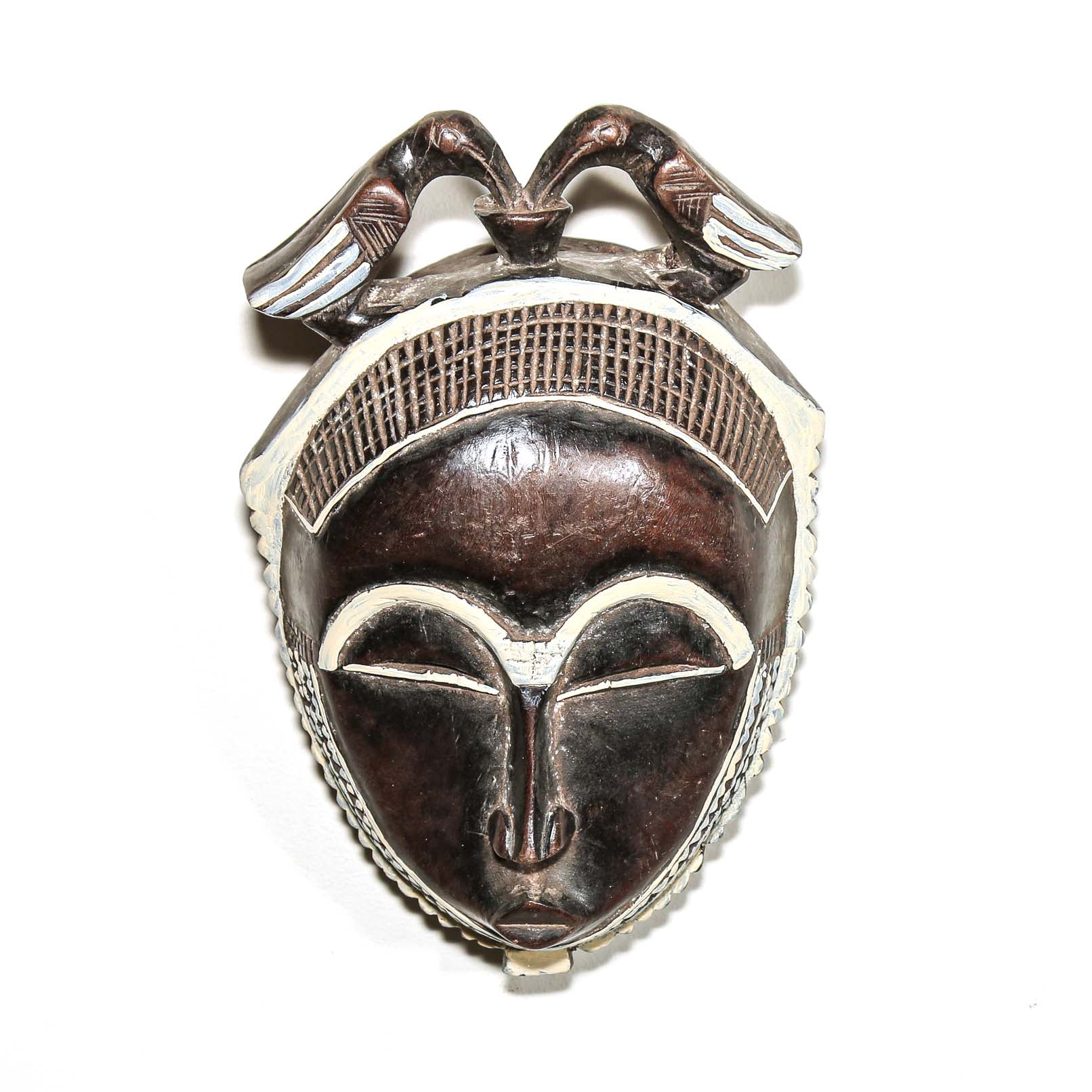 Decorative fine art african mask with red and blue accents on a white background. Traditional art for sale 