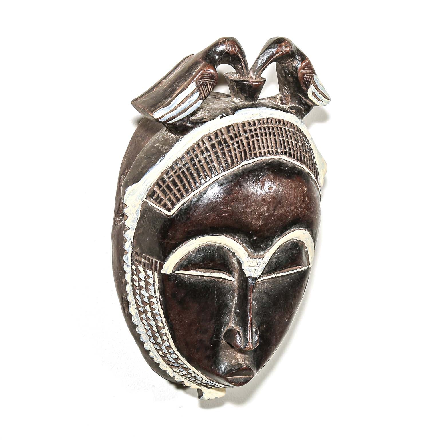 Decorative fine art african mask with white accents on a white background. Traditional art for sale 