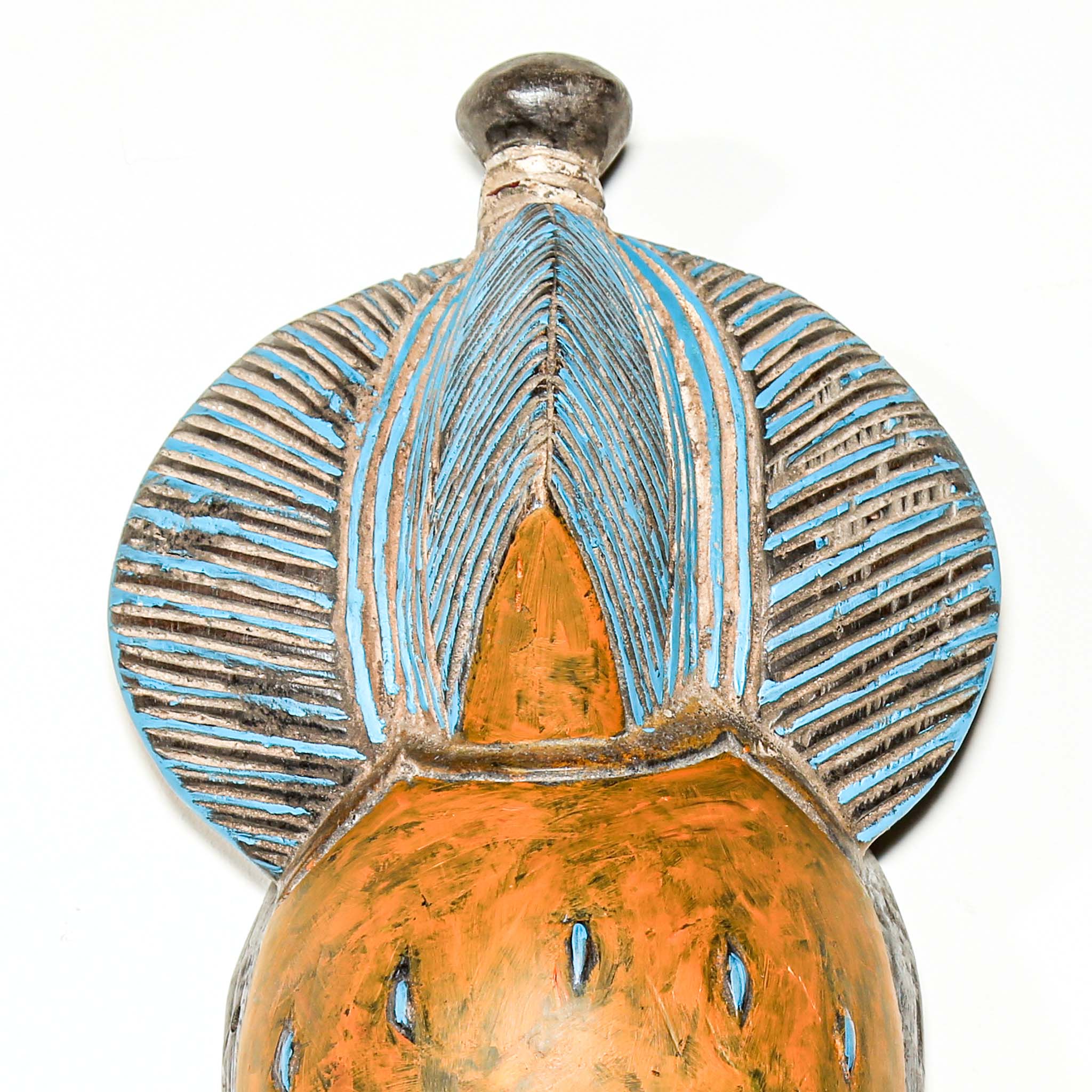 African art piece, specifically a yellow and blue wooden mask with geometric patterns on a white background. Tribal African art for sale.