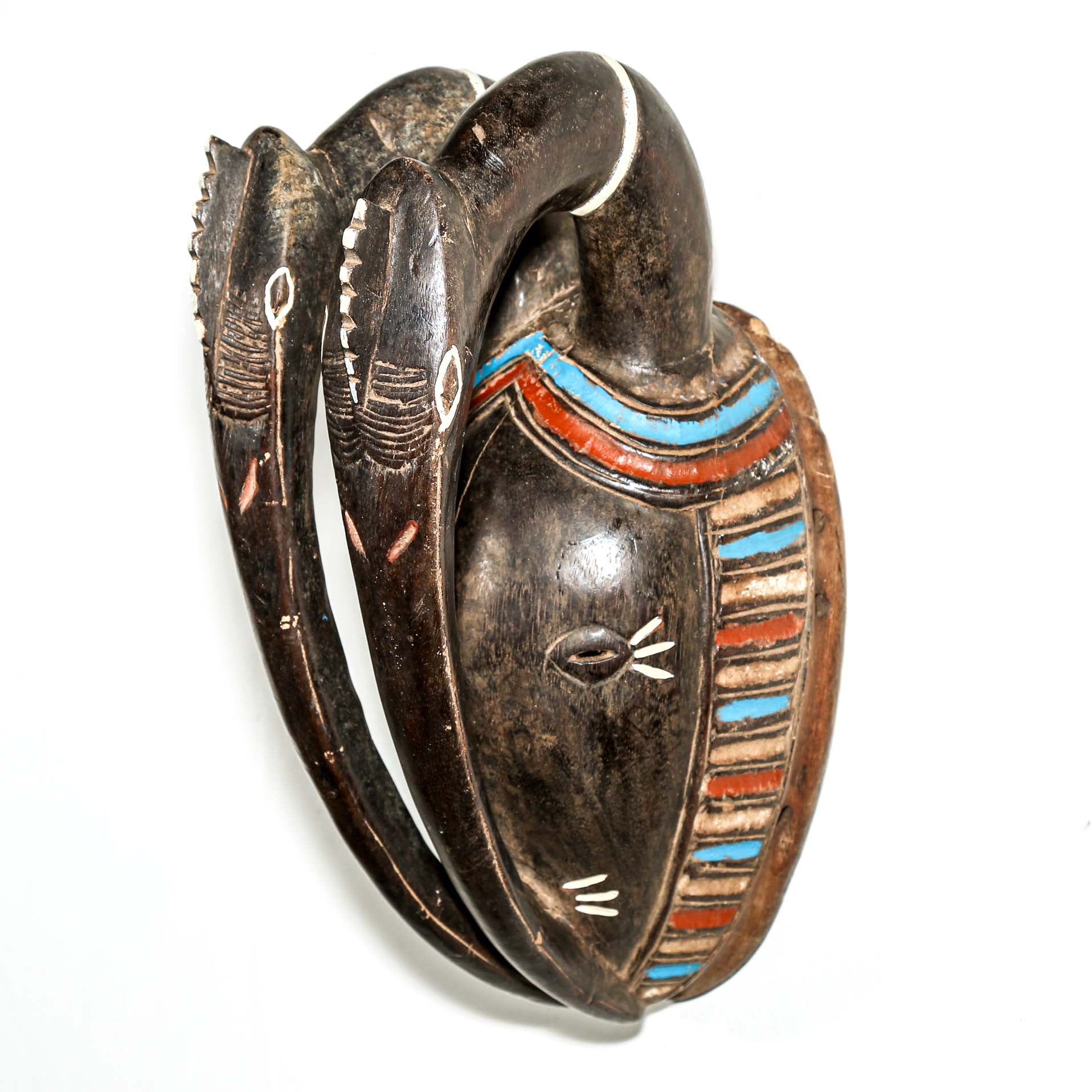 African art piece, specifically a yellow and blue wooden mask with geometric patterns on a white background. Tribal African art for sale.