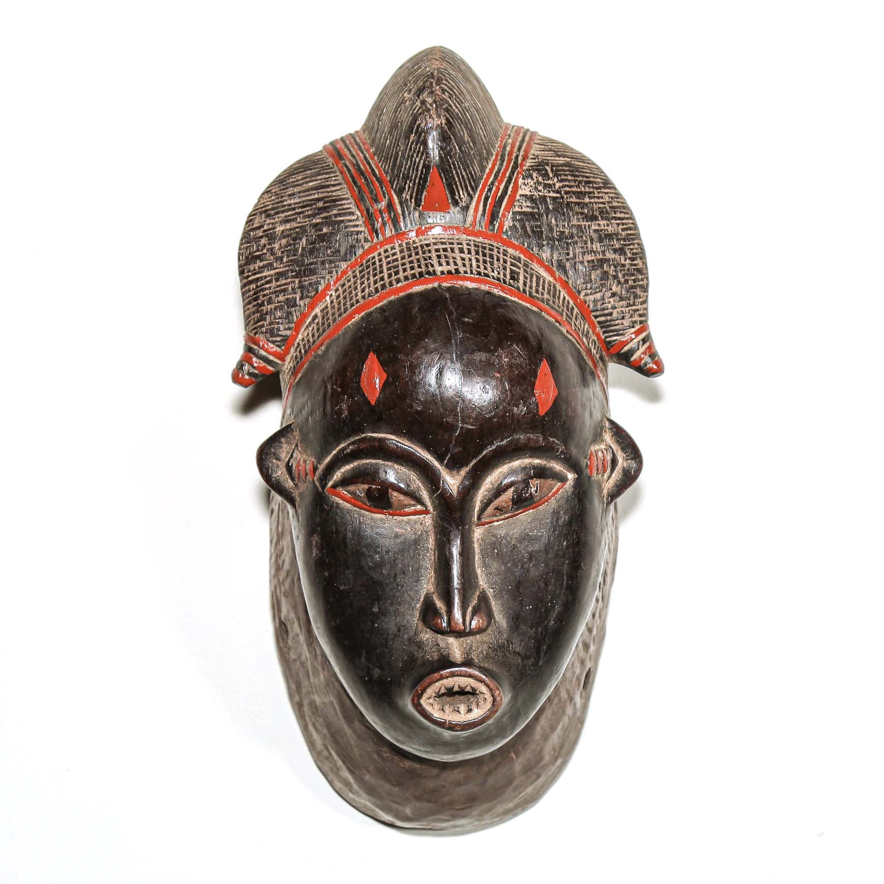 Wooden traditional African mask with black art face and red accents on a white background