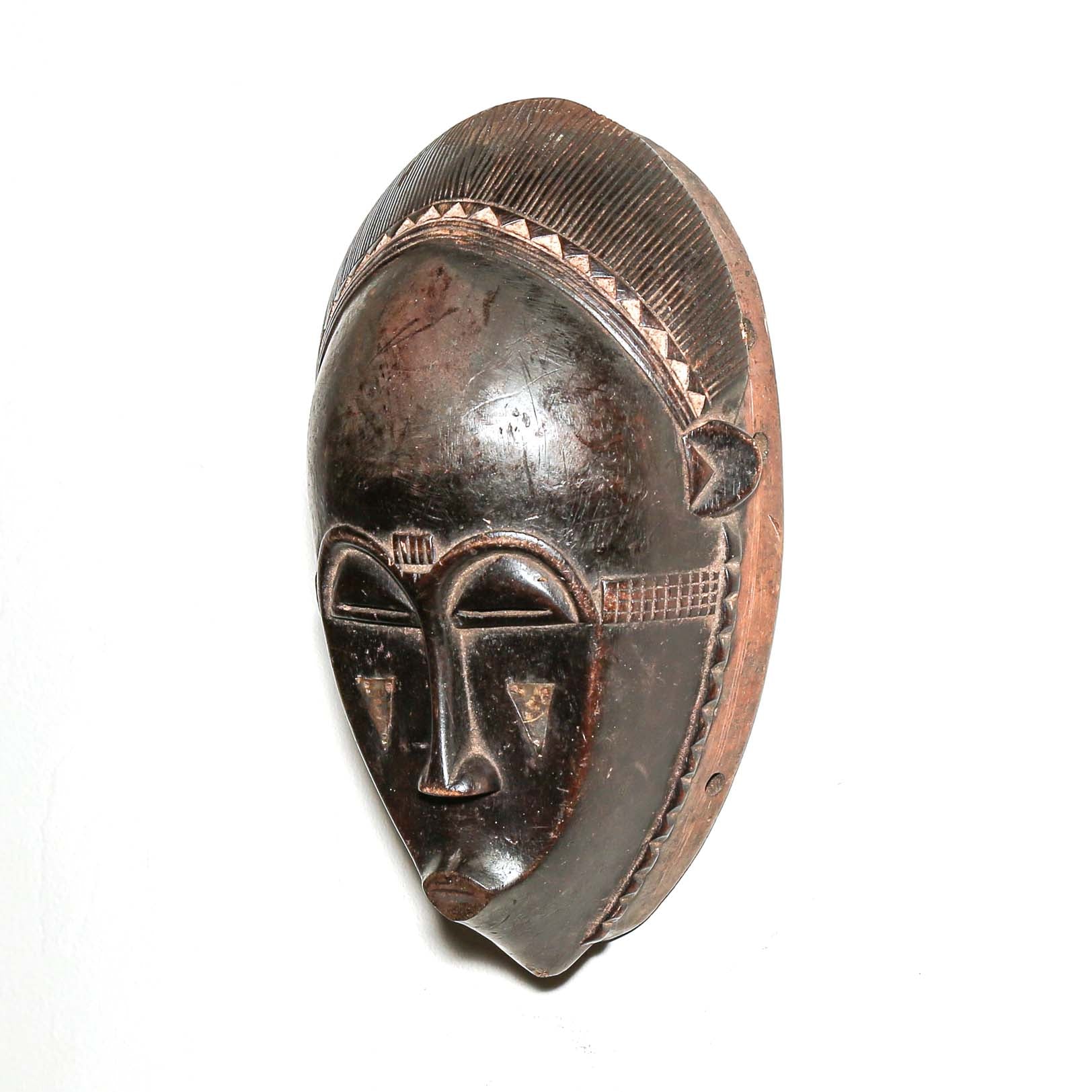 Wooden traditional African mask with black art face on a white background. Fine Art from Africa for sale