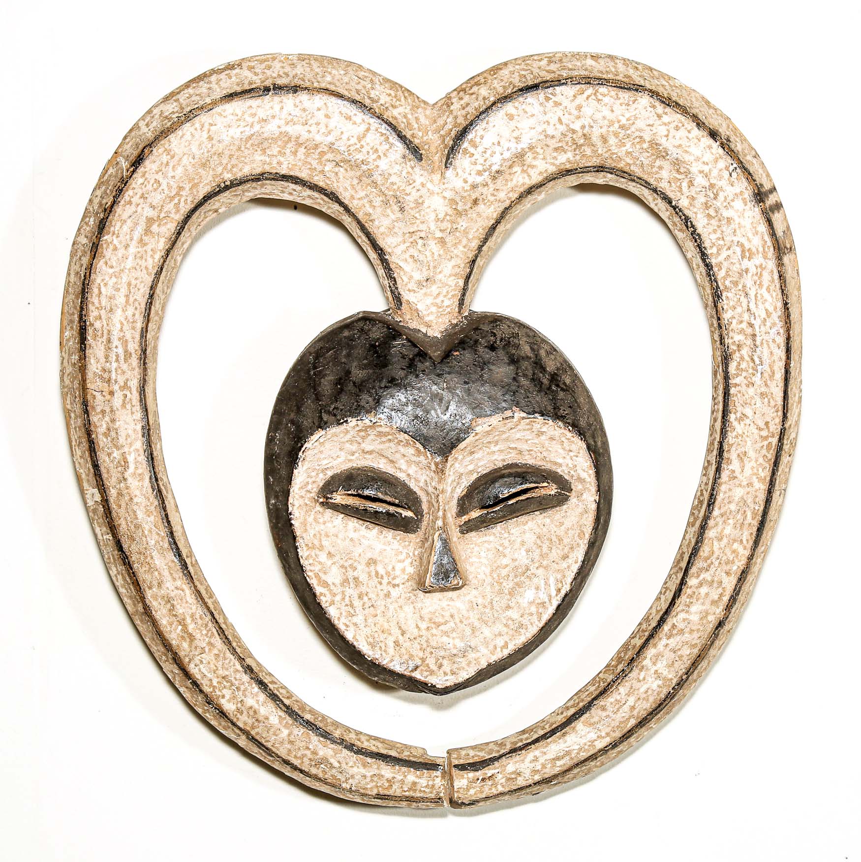 Decorative heart-shaped African mask with a face design on a white background