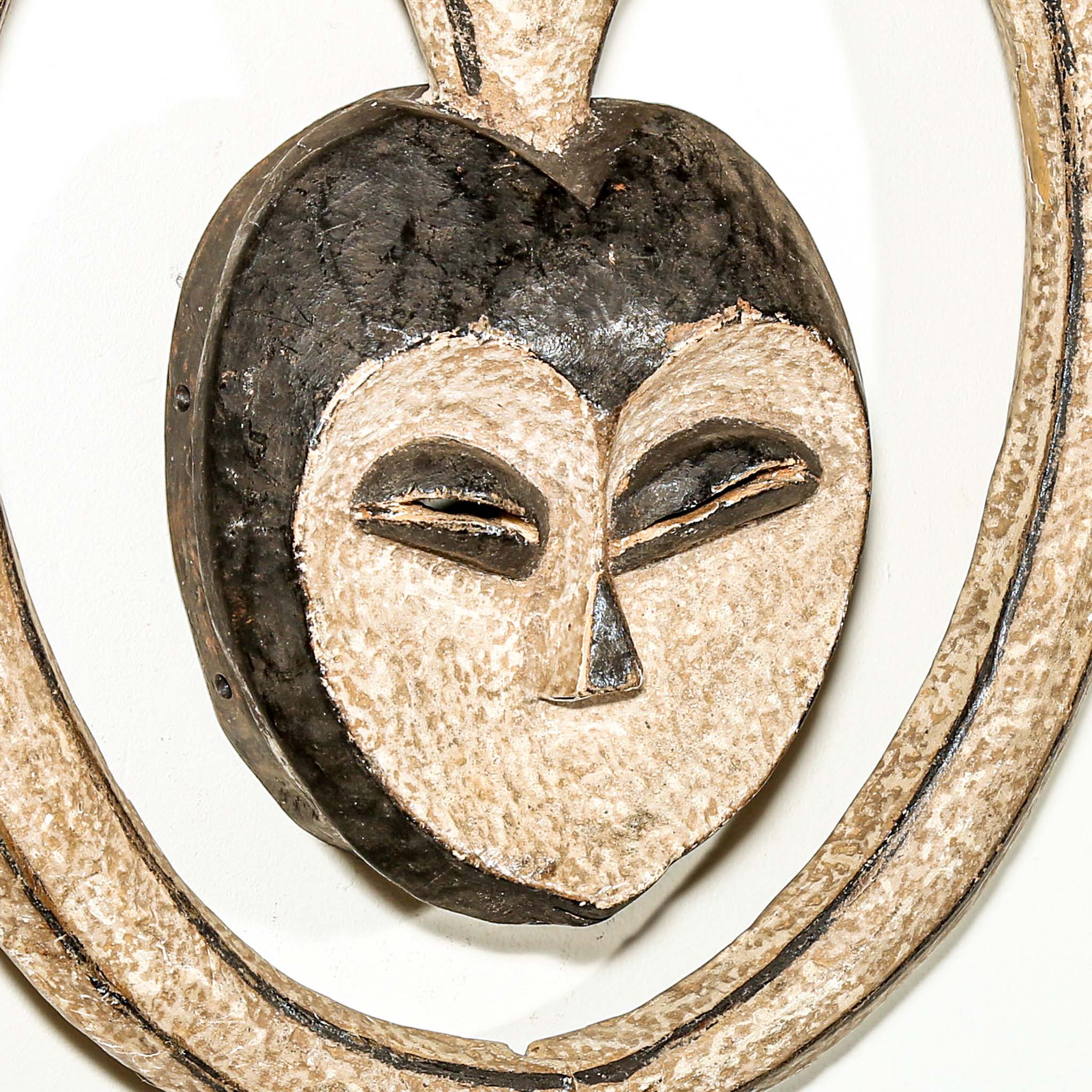Decorative heart-shaped African mask with a face design on a white background African art for sale close up