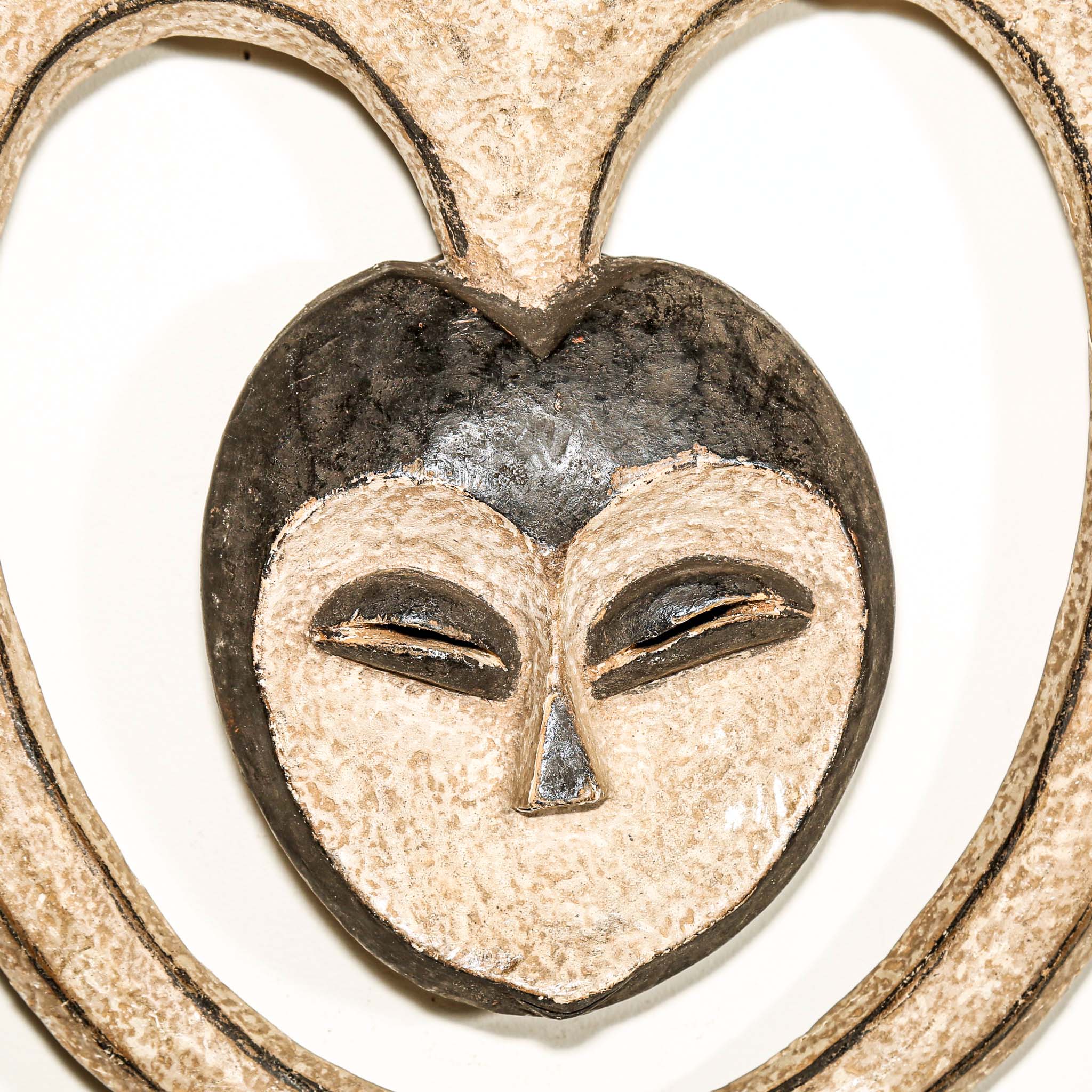 Decorative heart-shaped African mask with a face design on a white background African art for sale