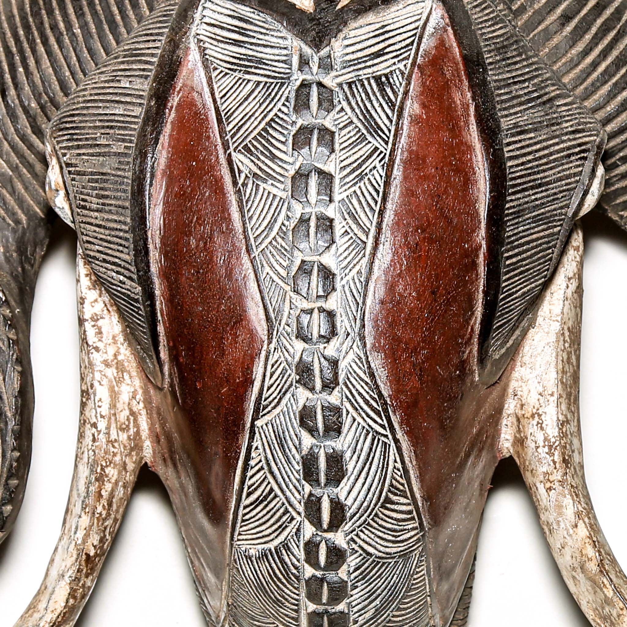 high end African ram's head sculpture with intricate patterns on a white background