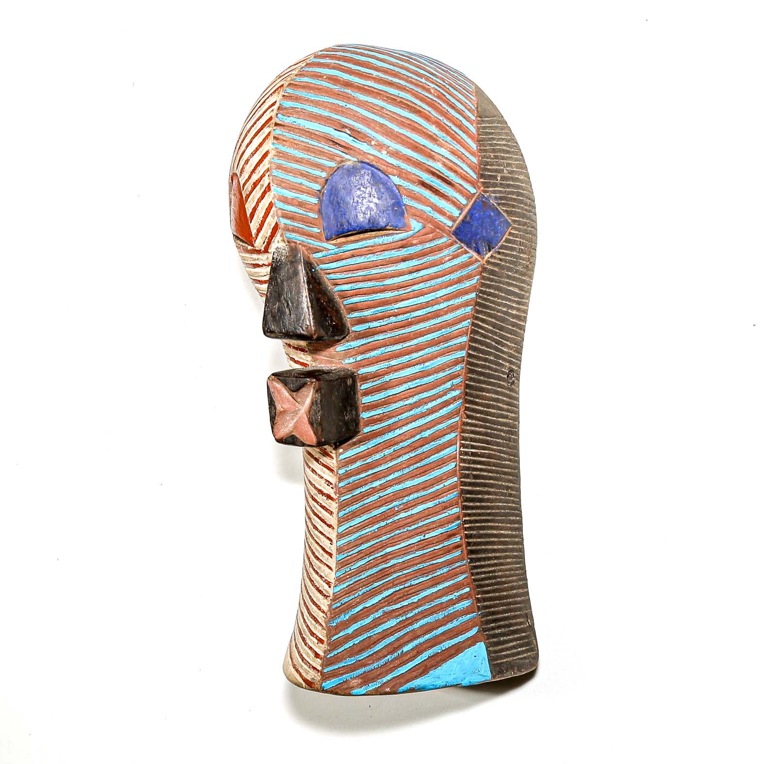 Wood African mask from the Congo with striped red white blue brown design on a white wall for sale