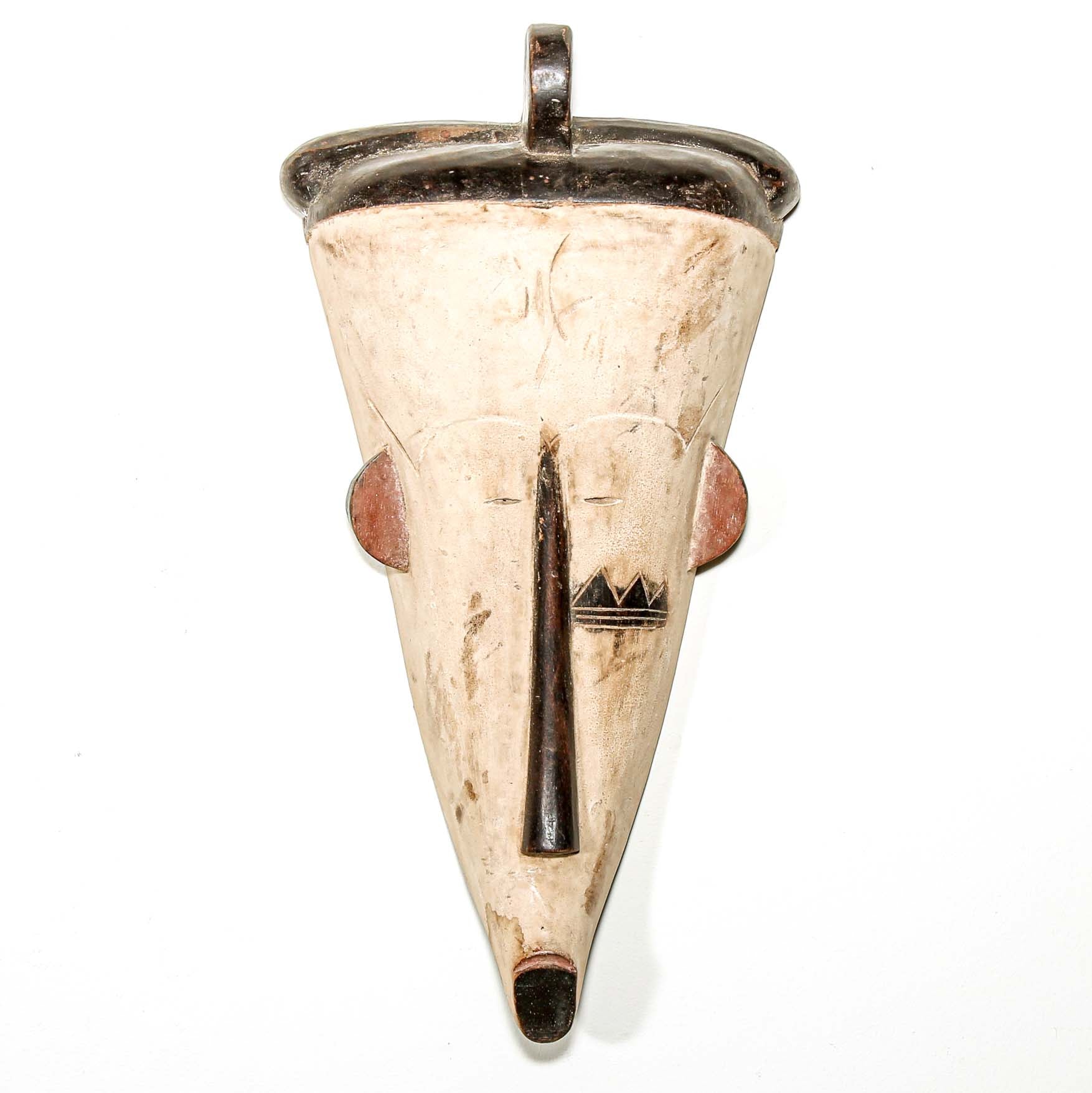Tribal-style wood mask with a cone shape and decorative elements on a white background