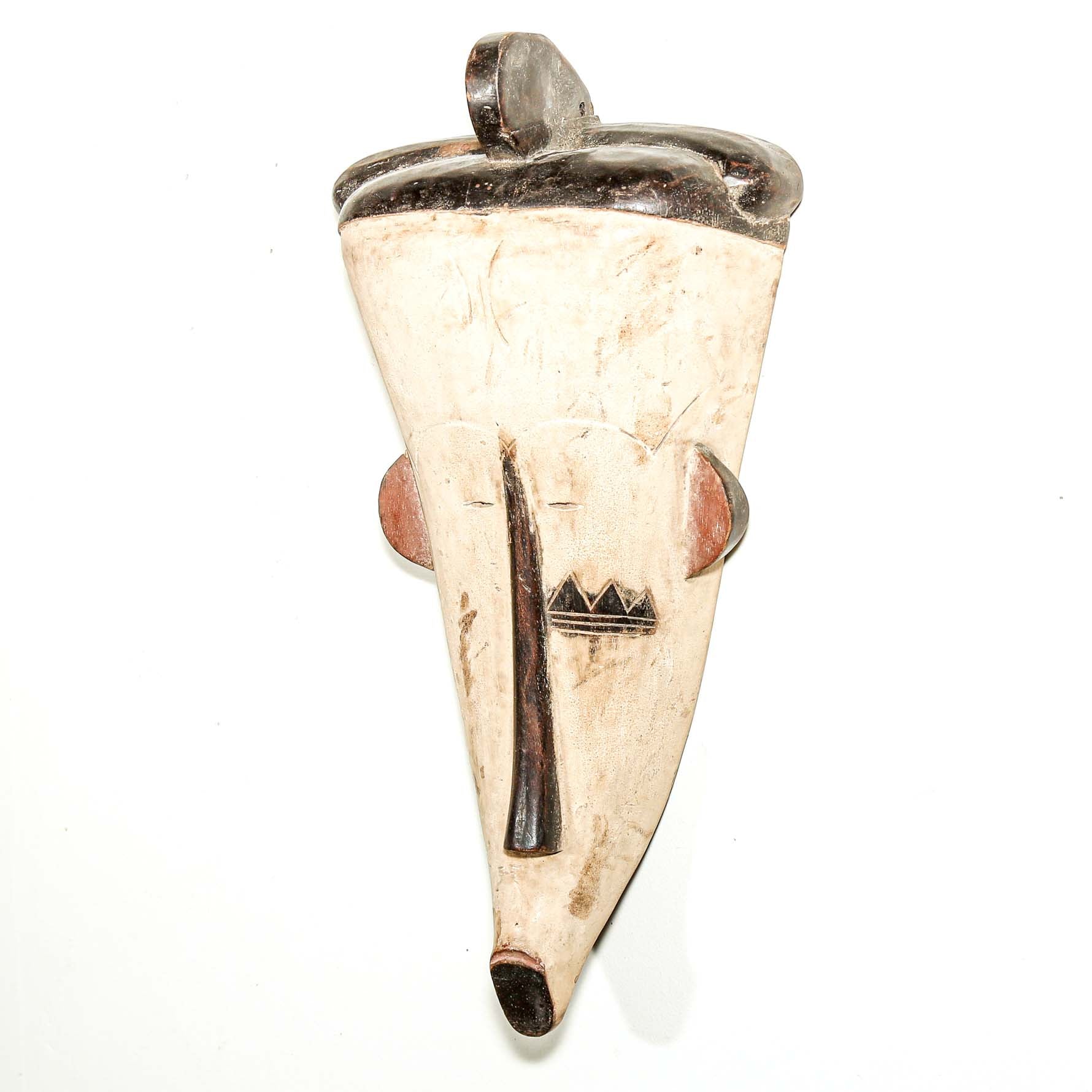 white hand carved wood Fang tribe wall mask with tribal designs on a white background