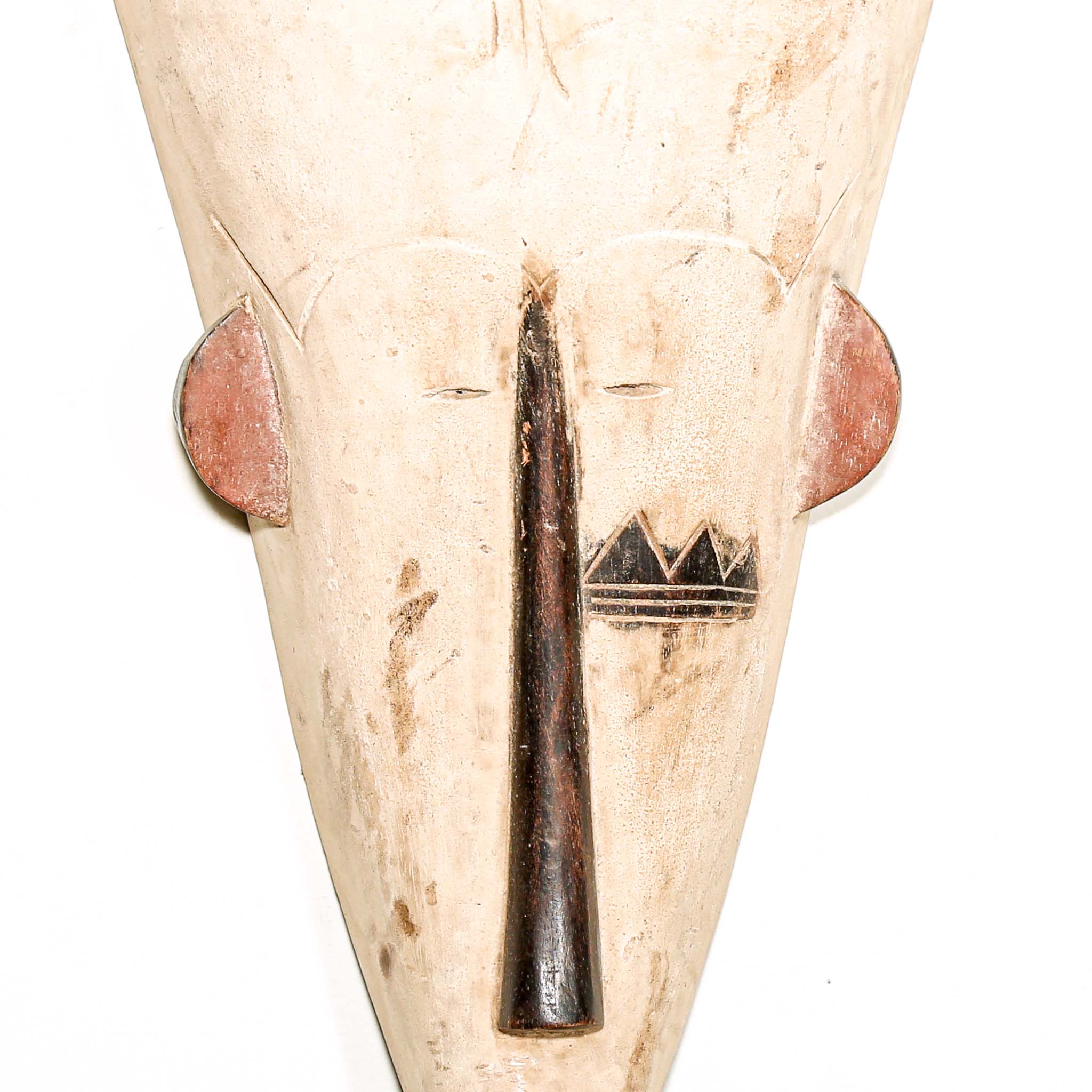 white hand carved wood Fang tribe wall mask with tribal designs on a white background