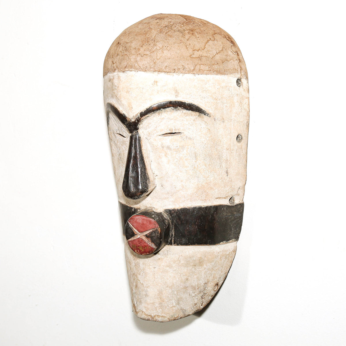 black and white African mask in the modern Songye style to hang on the bedroom wall for protection
