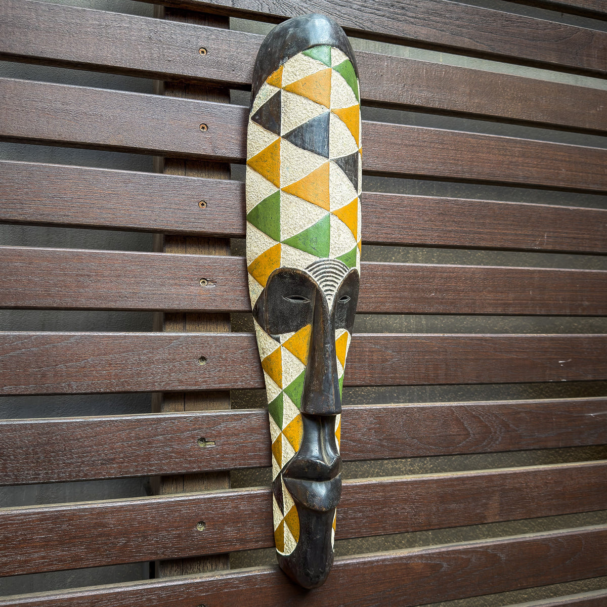 Hand-carved Fang-inspired mask from Gabon featuring vibrant colors, a long face, and sculptural Central African styling