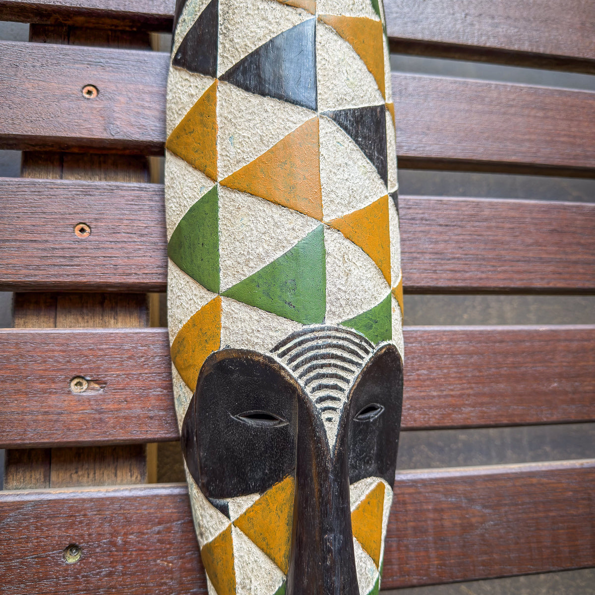 Gabonese Fang-style mask with bright decorative accents, carved wood construction, and expressive sculptural features