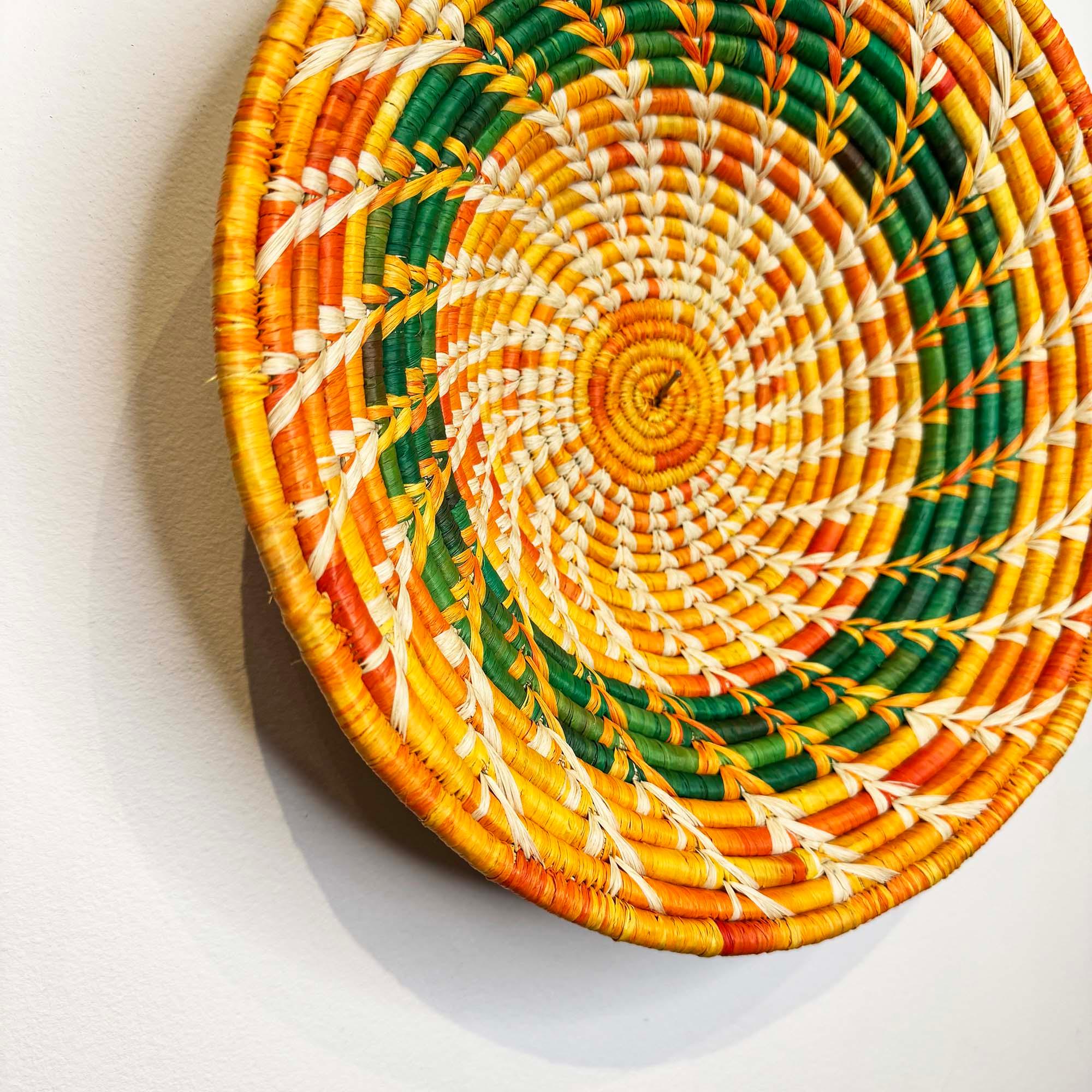 Orange-Green Woven Basket Handmade in Uganda as a wall decor with a close up