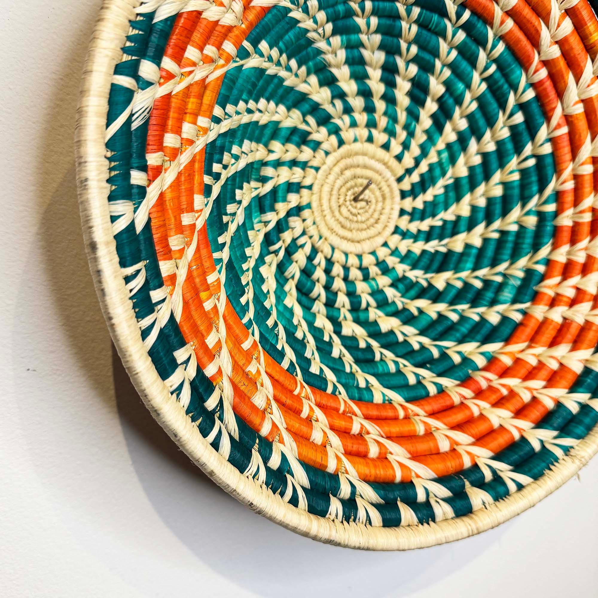 Orange-Teal Woven Basket from Uganda as a wall decor idea on a close up 