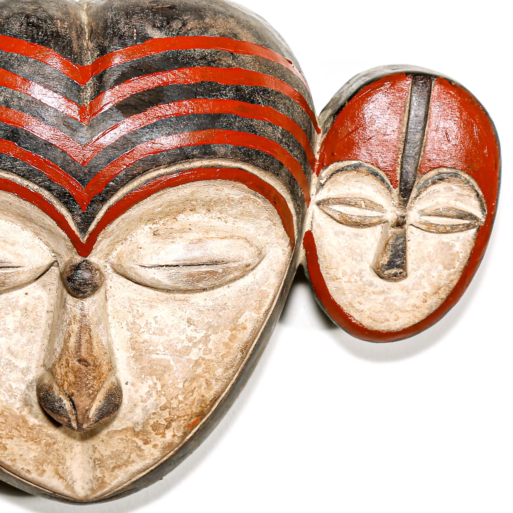 African-style mask with red and black patterns on a white background