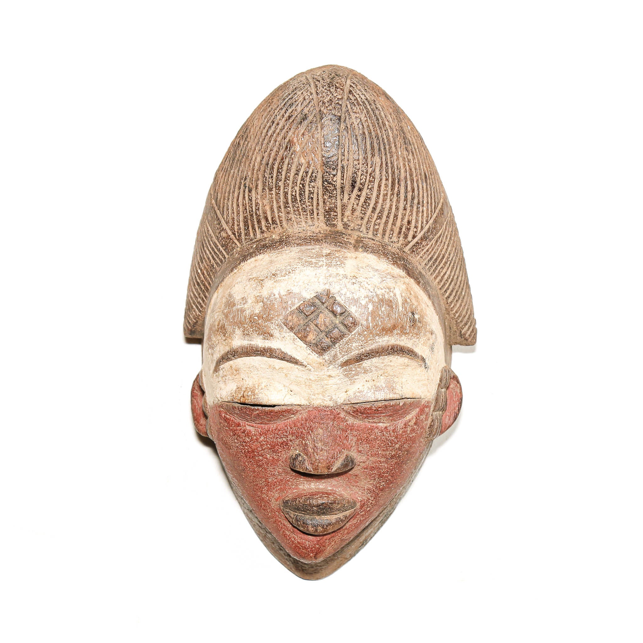 An antique carved African wooden mask with a tall textured hairpiece, featuring a weathered beige forehead with a diamond motif and a reddish-brown painted lower face, isolated on a white background.