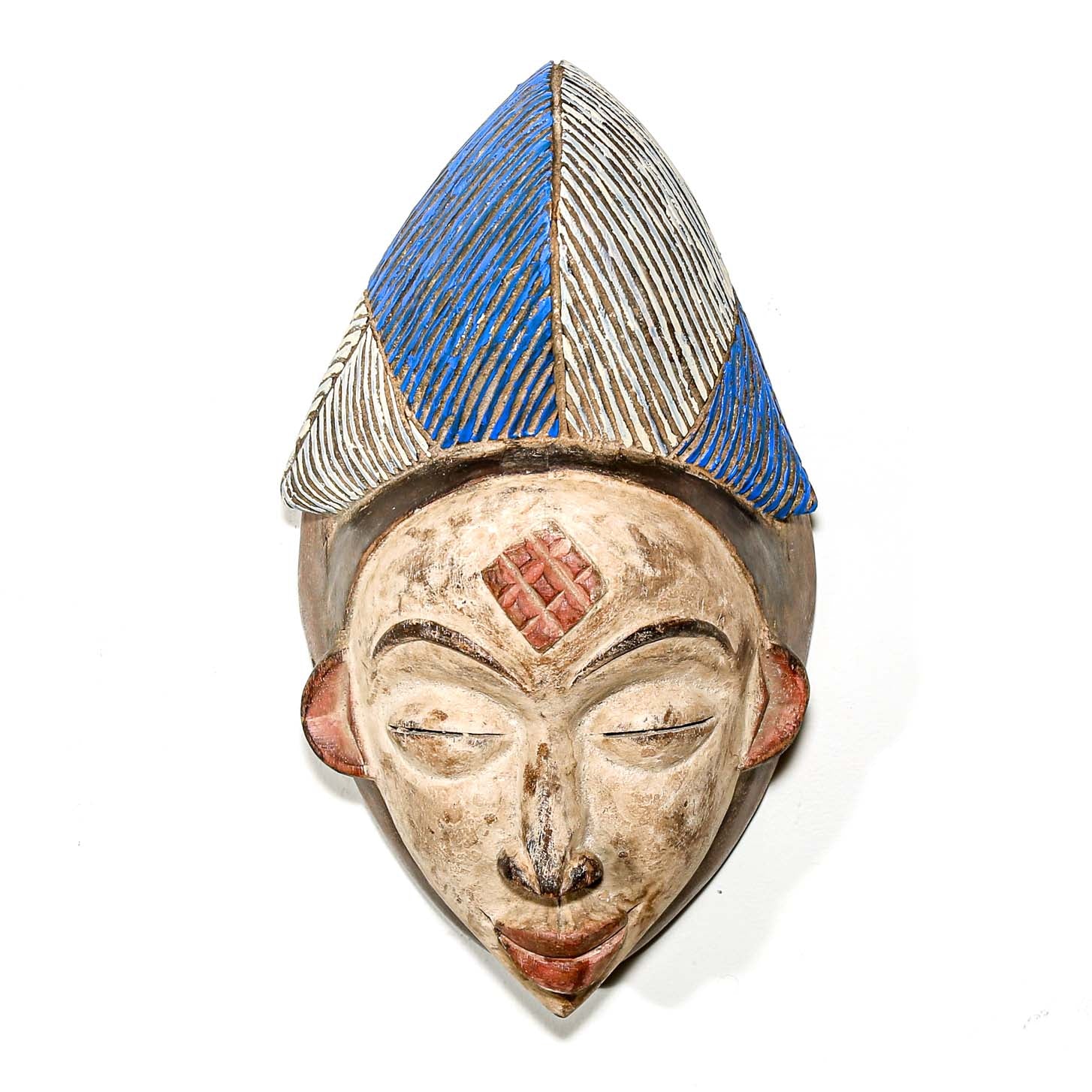 Traditional wooden mask from Africa with blue and silver headdress on a white background