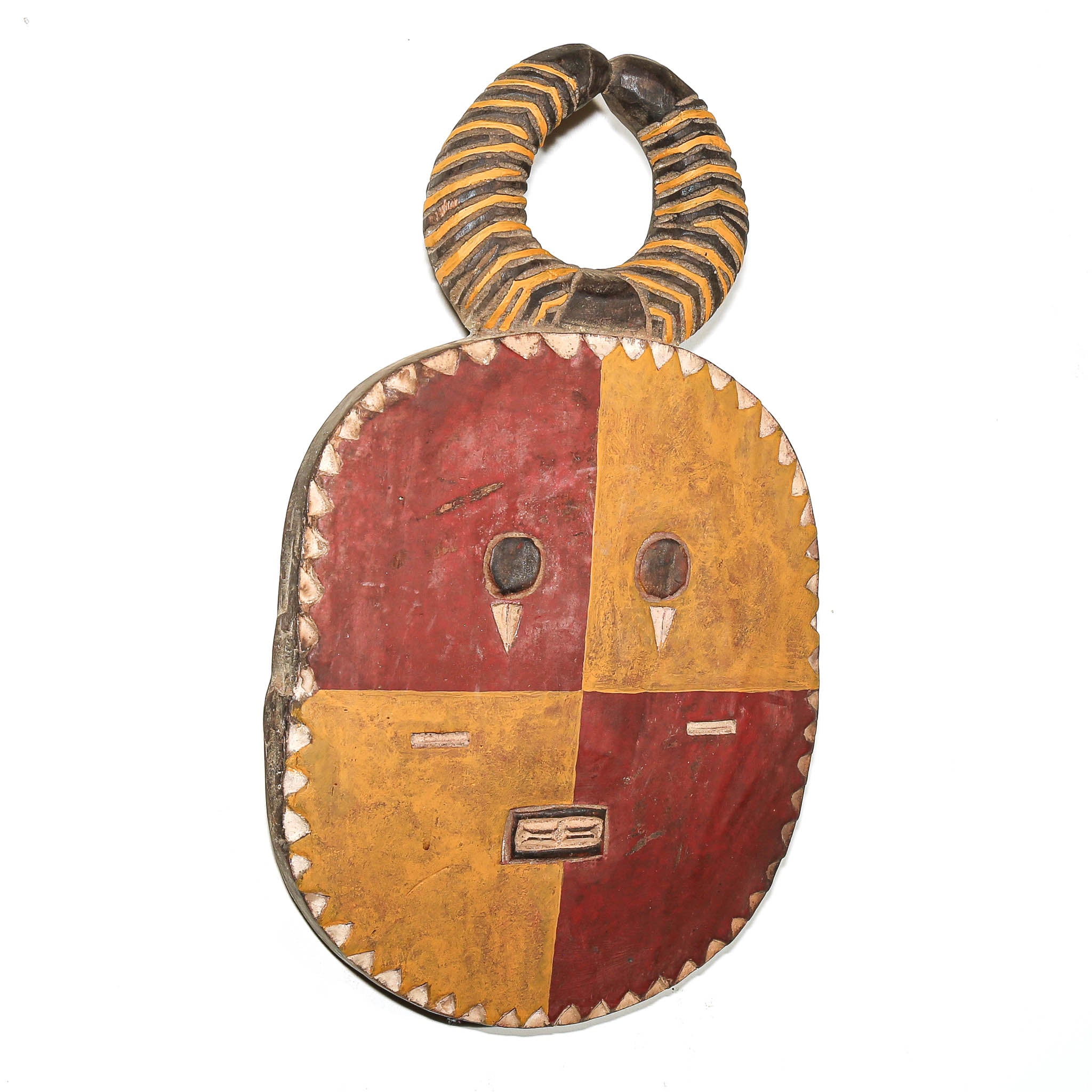 A handcrafted African wooden mask with a four-quadrant face painted in red and ochre yellow, featuring a striped handle and carved facial details.