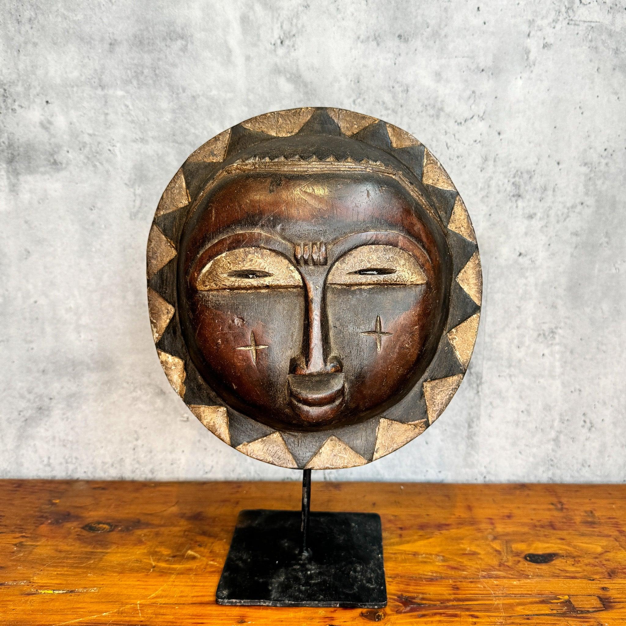 Baule Sun Mask from Cote d'Ivoire displayed on a stand as an African mask