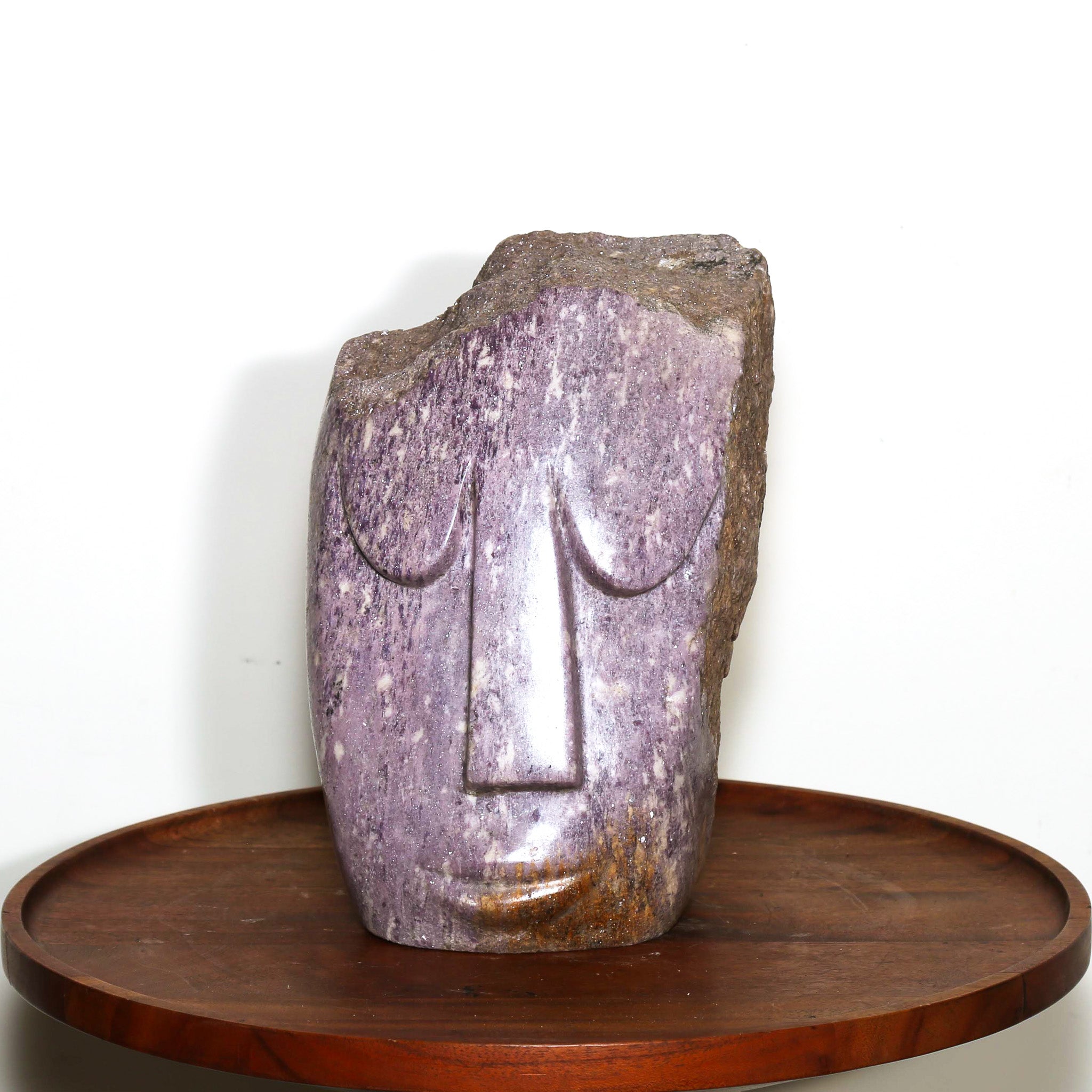 purple rock carving of a head