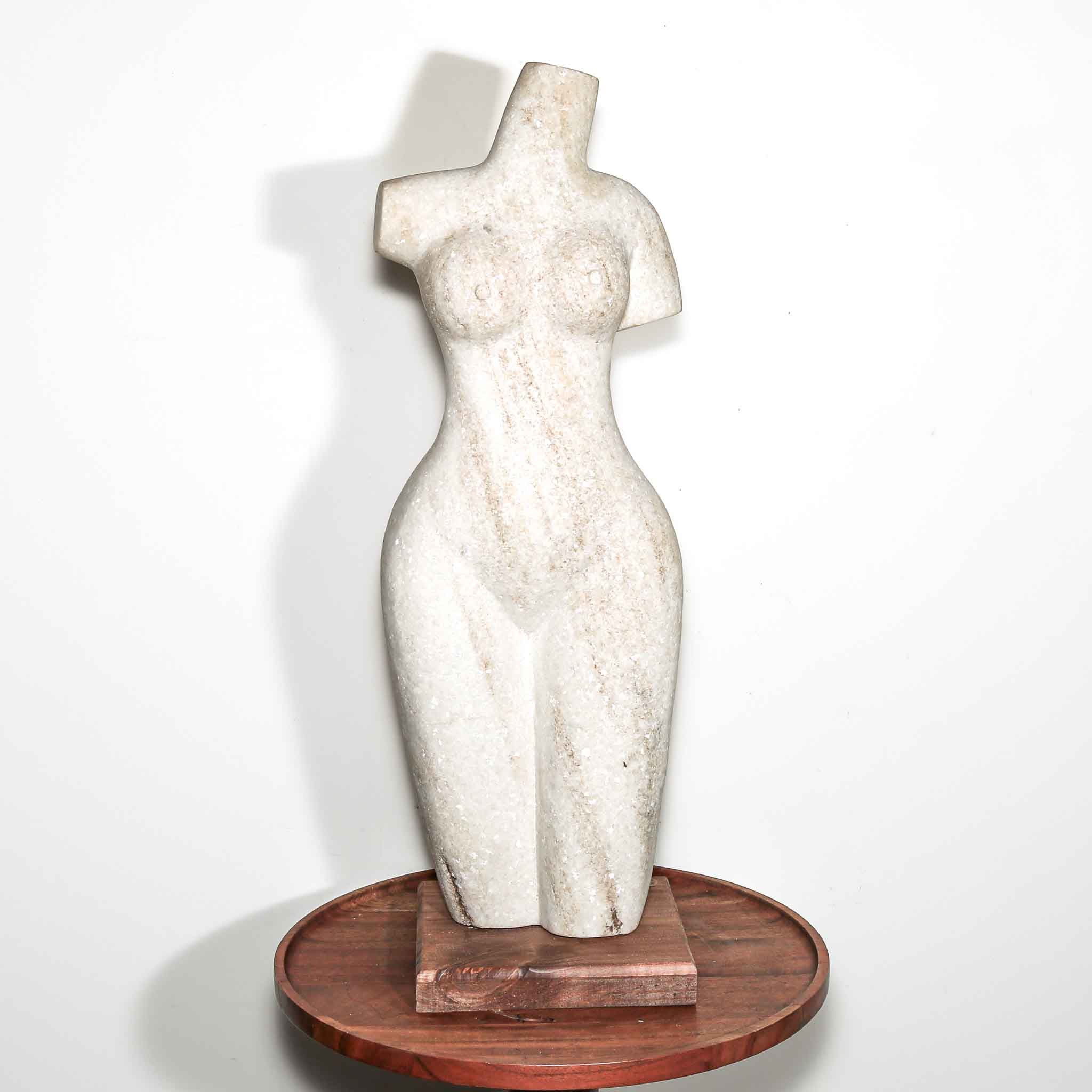 white stone statue of a woman. hand carved female artist