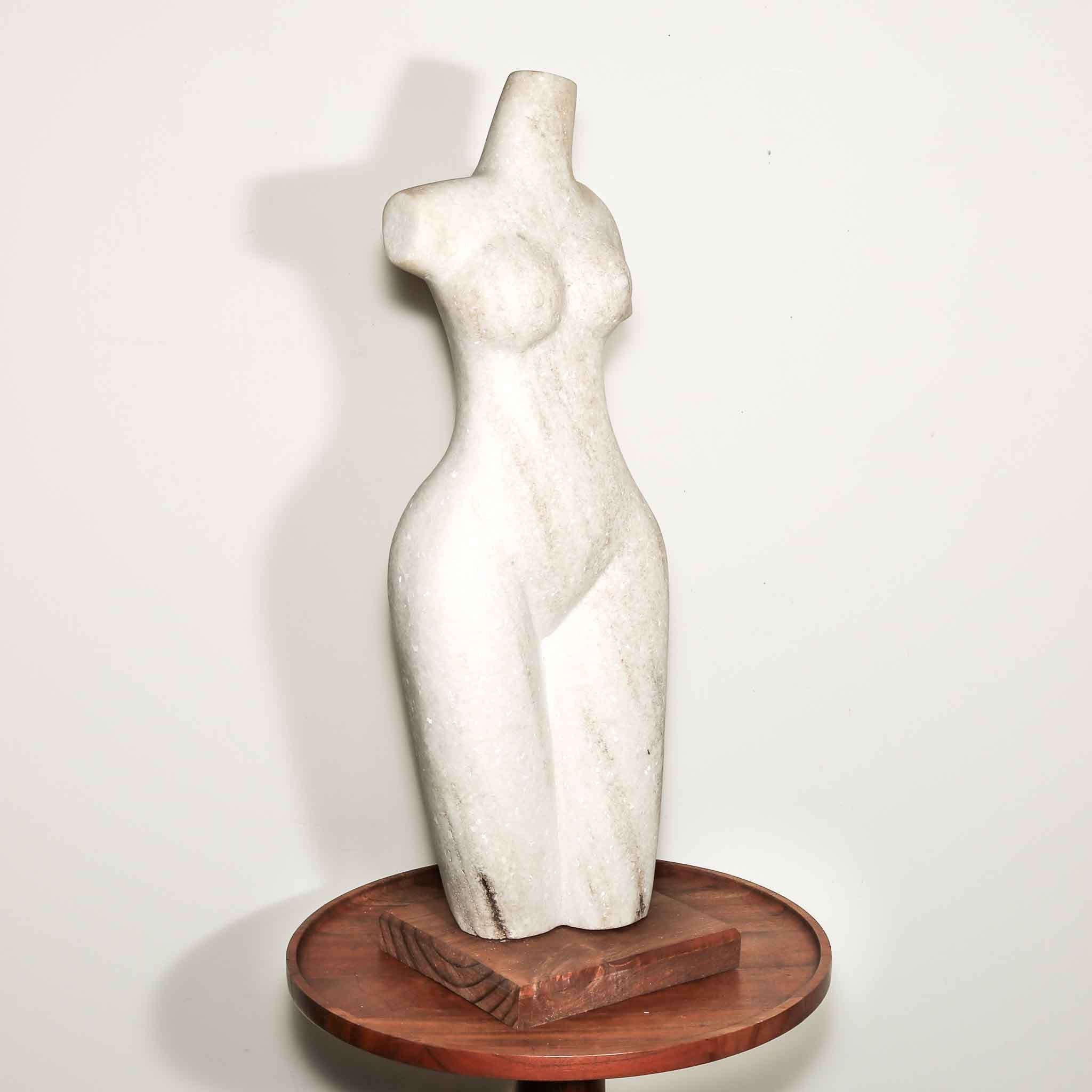 white stone statue of a woman. hand carved female artist