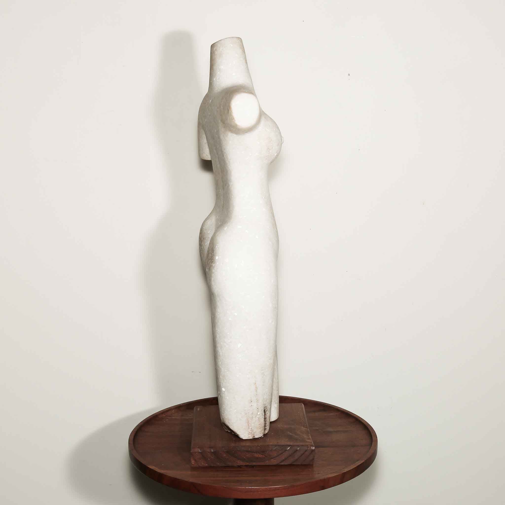 white stone statue of a woman. hand carved female artist