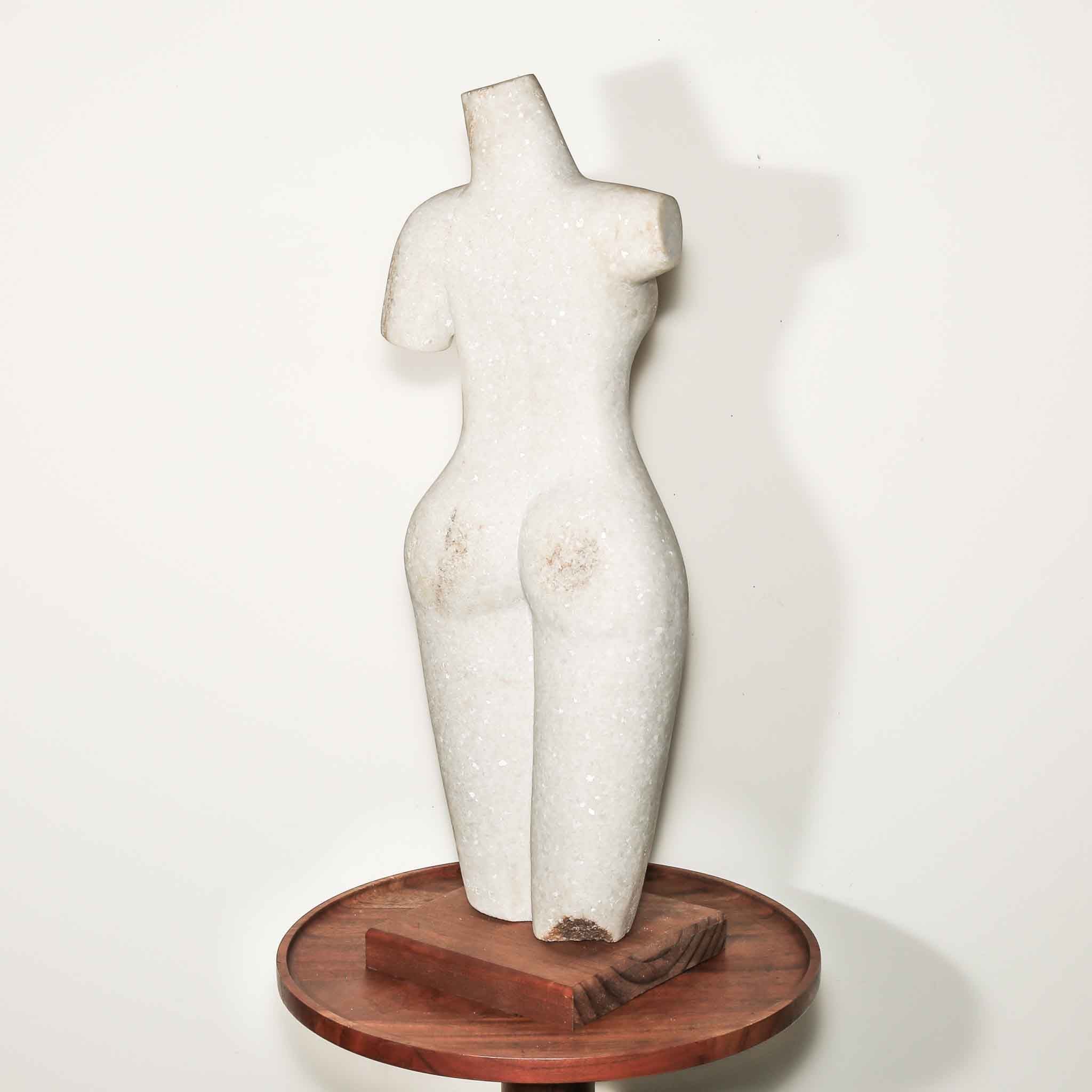 white stone statue of a woman. hand carved female artist