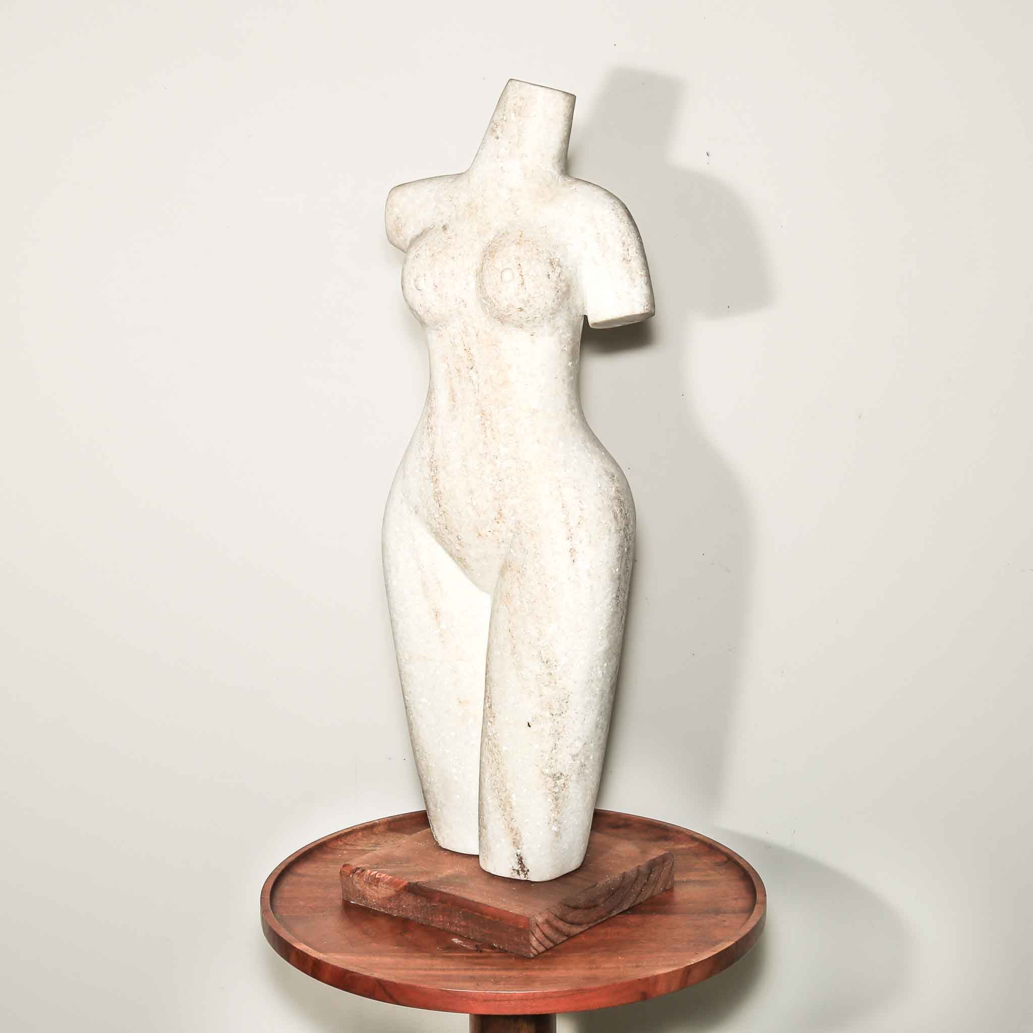 white stone statue of a woman. hand carved female artist