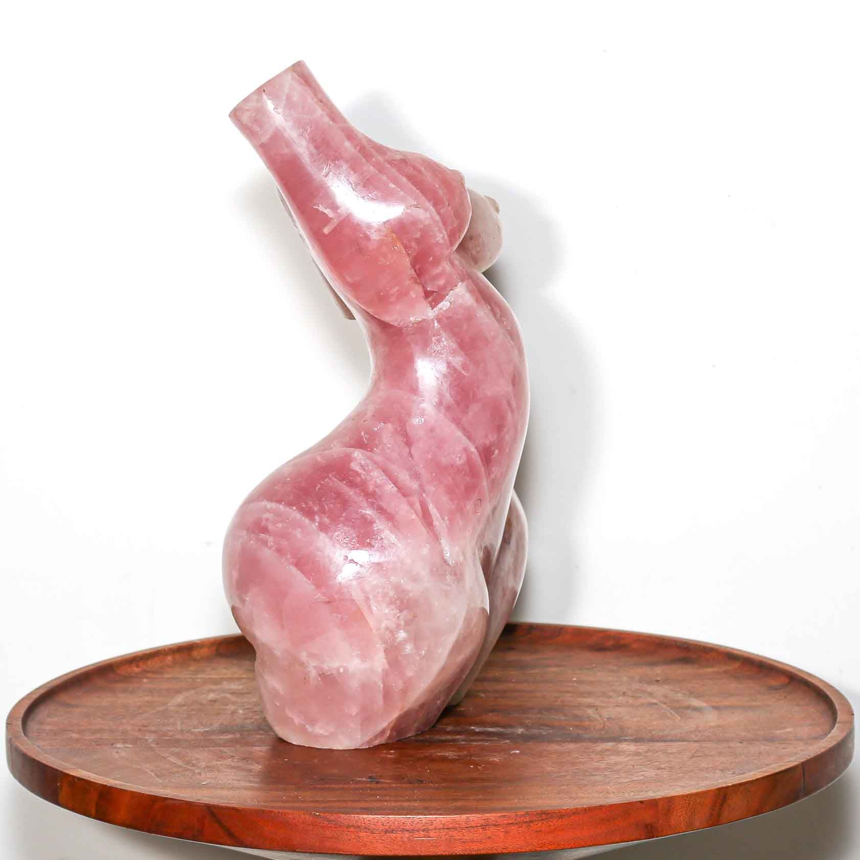 pink sculpture of a woman made out of carved Rose Quartz