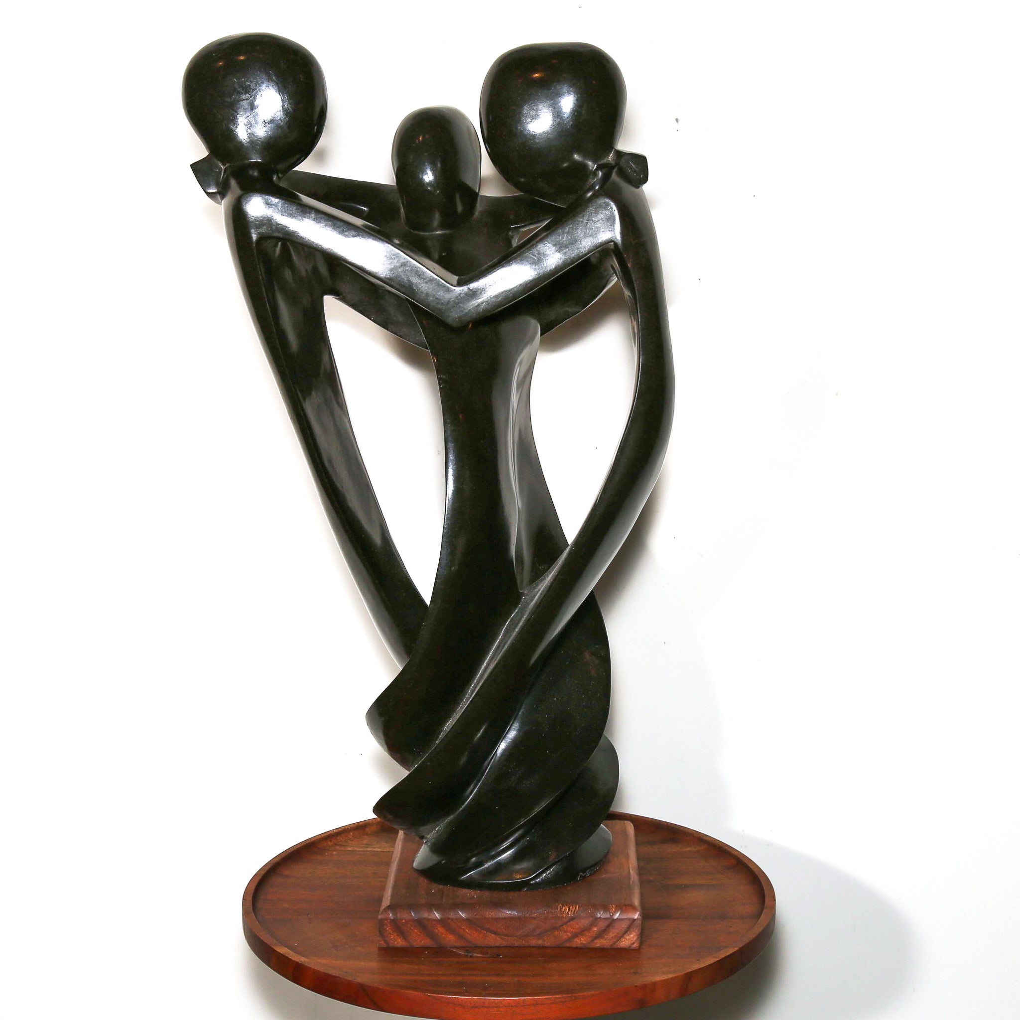 family of three hugging as a sculpture