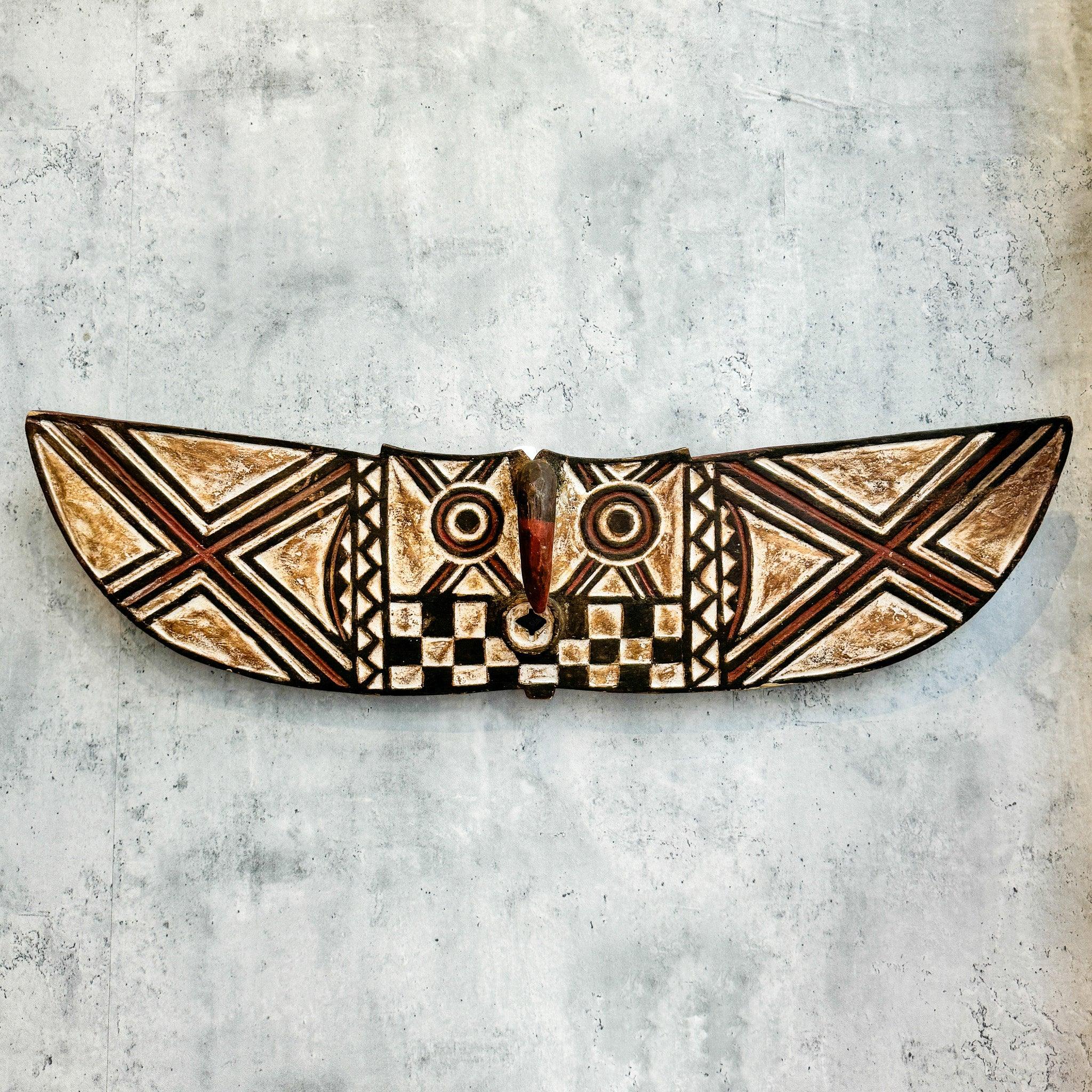 Butterfly Mask from Burkina Faso as an African mask wall decor idea on a concrete wall 