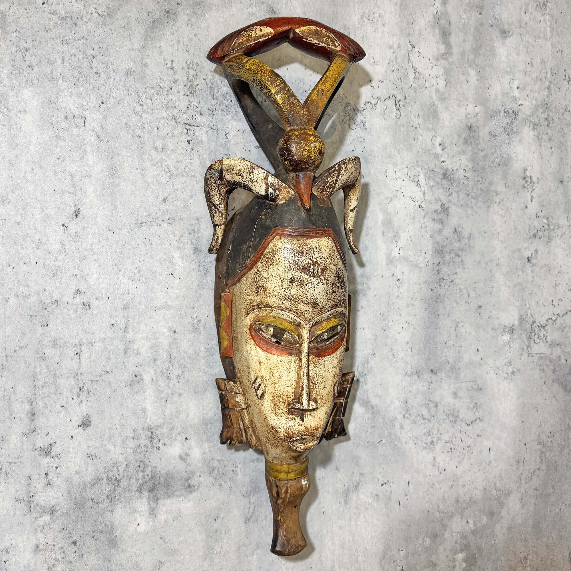 Right side of Guro Mask from Côte d'Ivoire hanging on a wall as a decoration