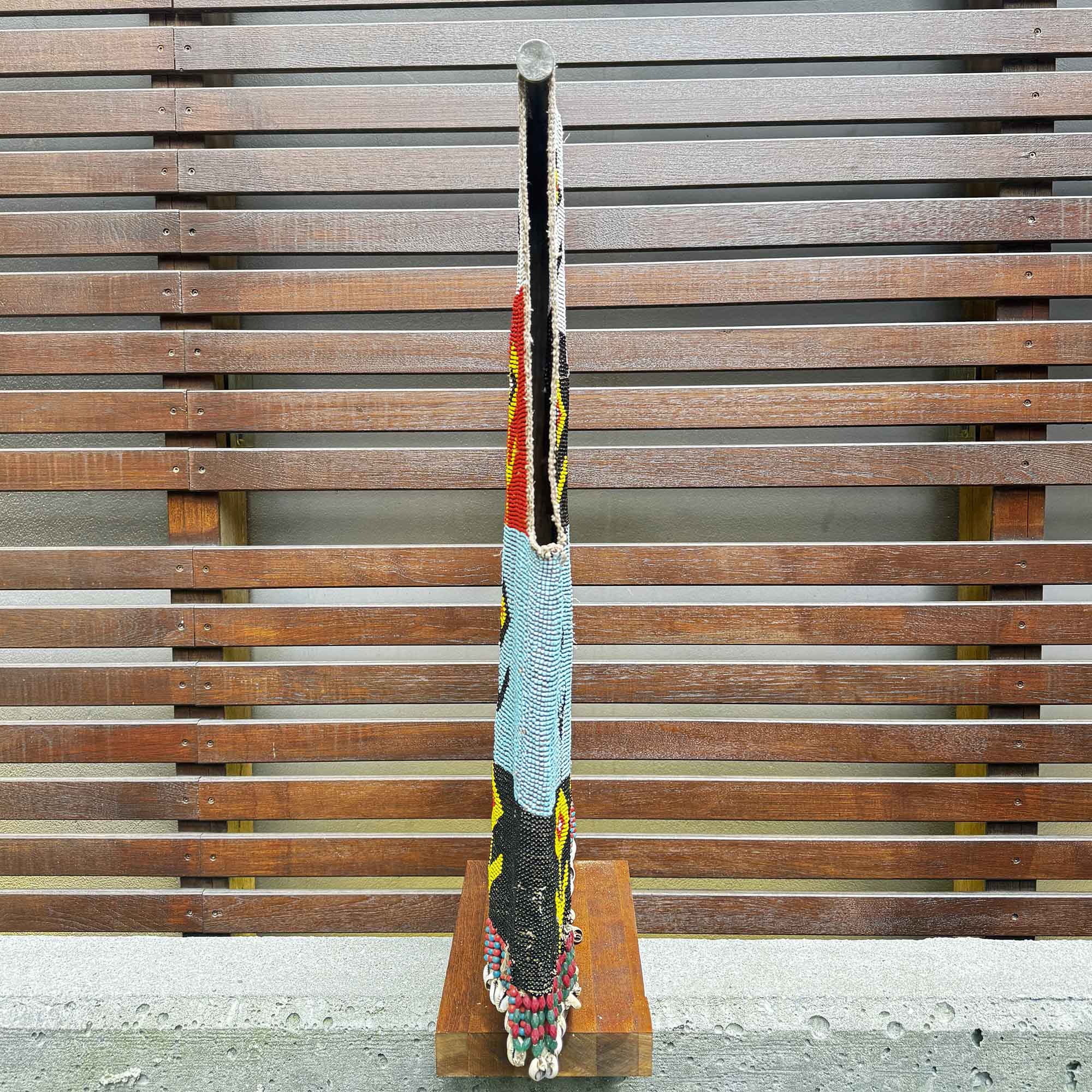 side view of beaded tunic from africa on a display stand from the side