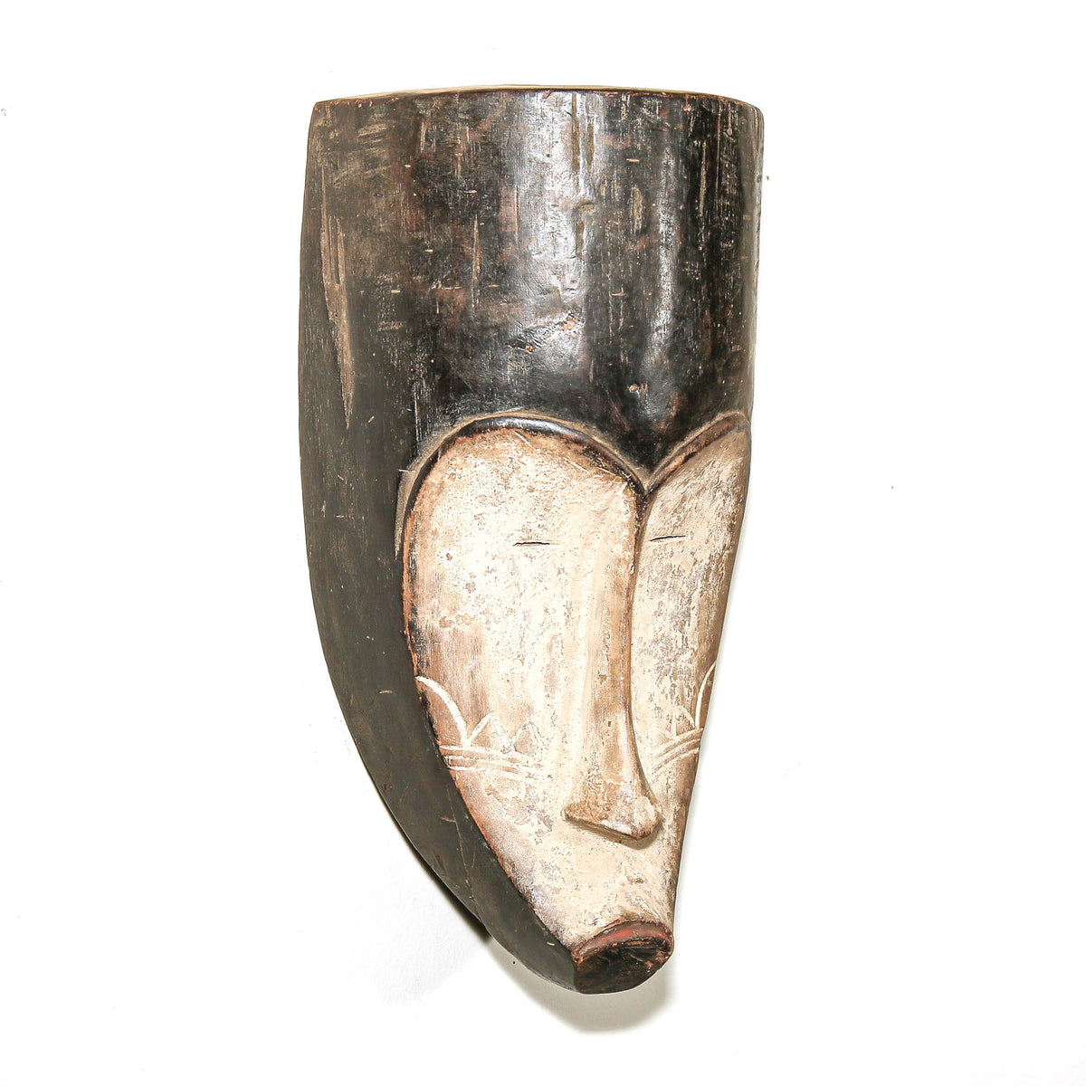 Traditional Fang African mask with black and white painted surface, elongated face, and sculptural carved wood form