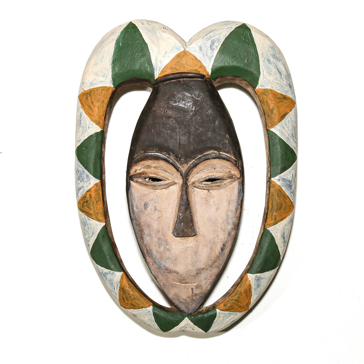 Kwele mask with green, yellow, and white painted patterns and a distinctive carved Central African form