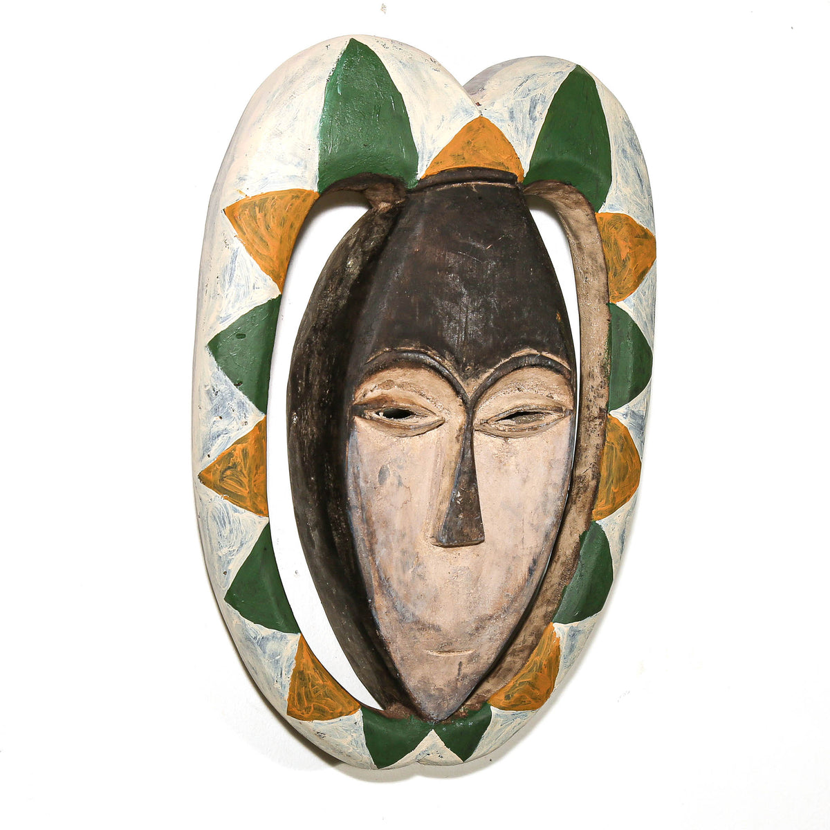 Hand-carved Kwele mask with colorful green, yellow, and white designs, displayed as collectible African tribal art