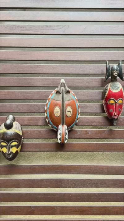 Video of three African masks hanging on a wooden wall