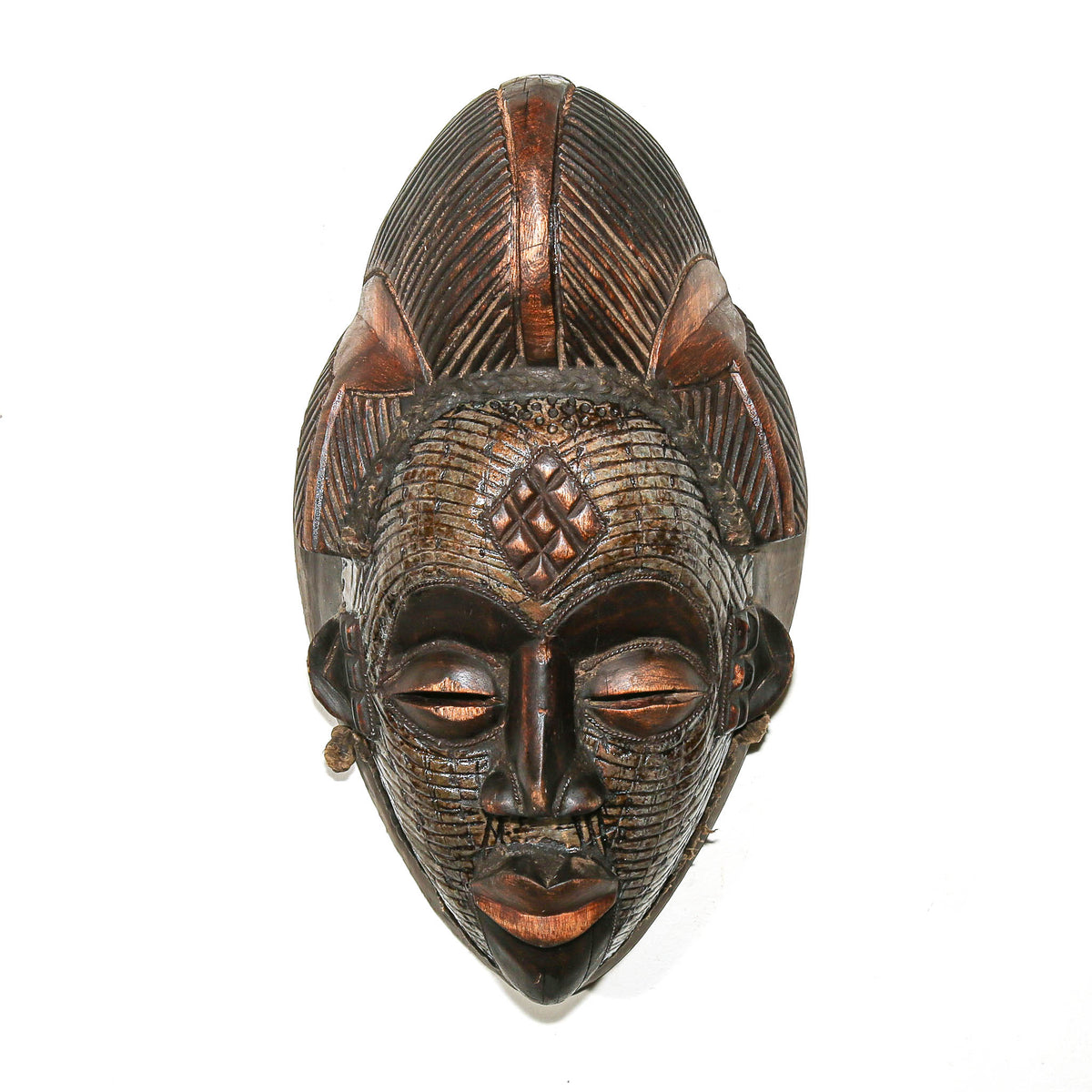 Punu mask from Gabon with metal details, refined carved facial features, and a distinctive sculptural wood form