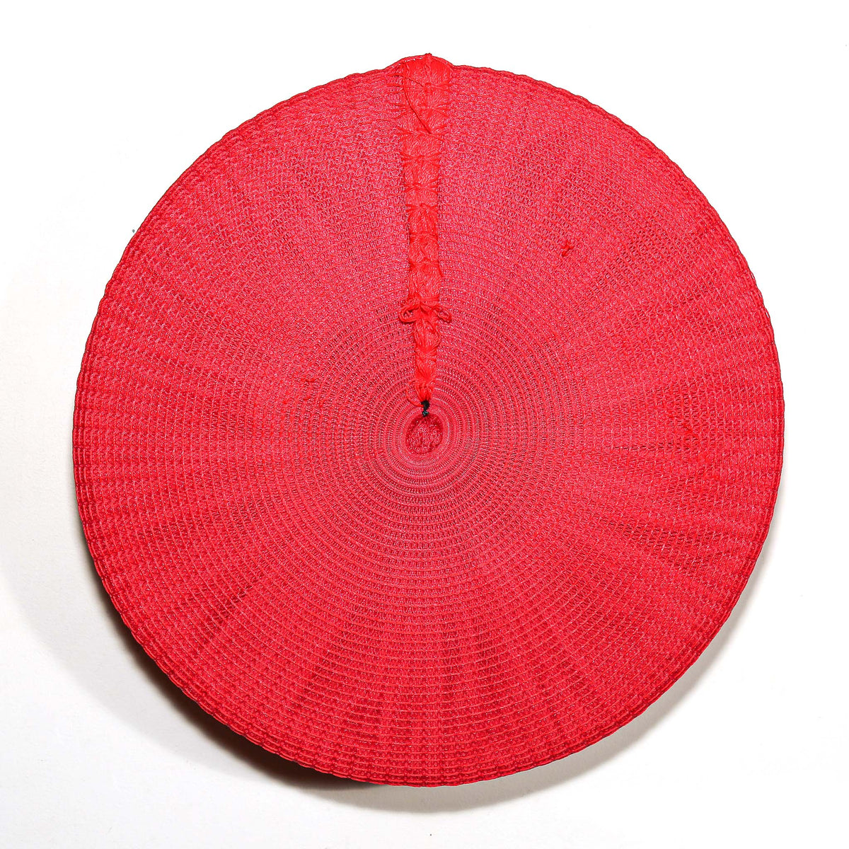 Bright red Zulu hat from South Africa with a rounded woven form, displayed as colorful African wall decor