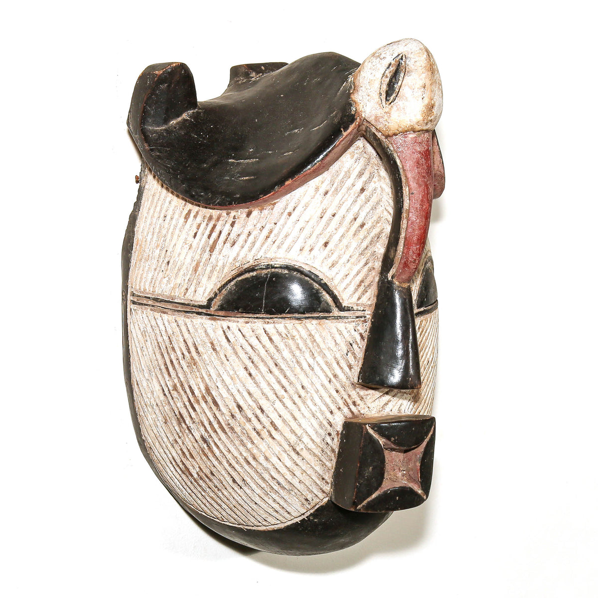 Hand-carved Songye face mask from Central Africa with contrasting black and white decoration and strong geometric patterning