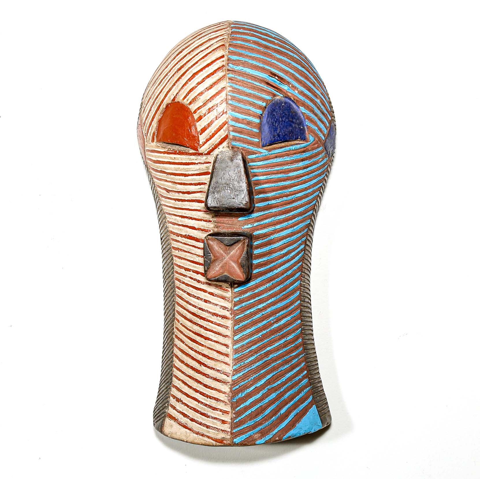 Wood African mask from the Congo with striped red white blue brown design on a white wall for sale