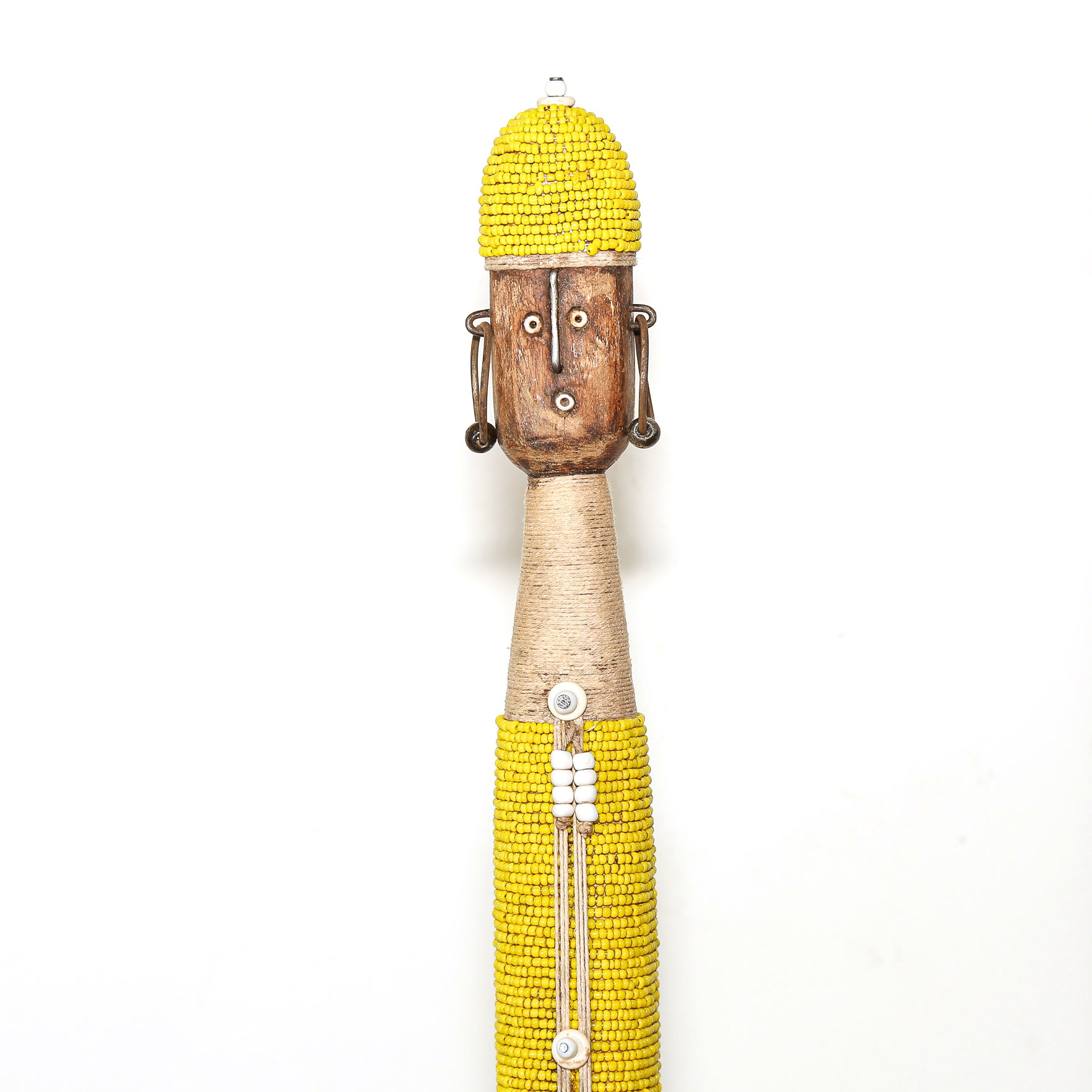A handcrafted African-style wooden figurine with a yellow beaded hat and skirt, a natural wood face, and a light-colored neck, shown against a plain white background.
