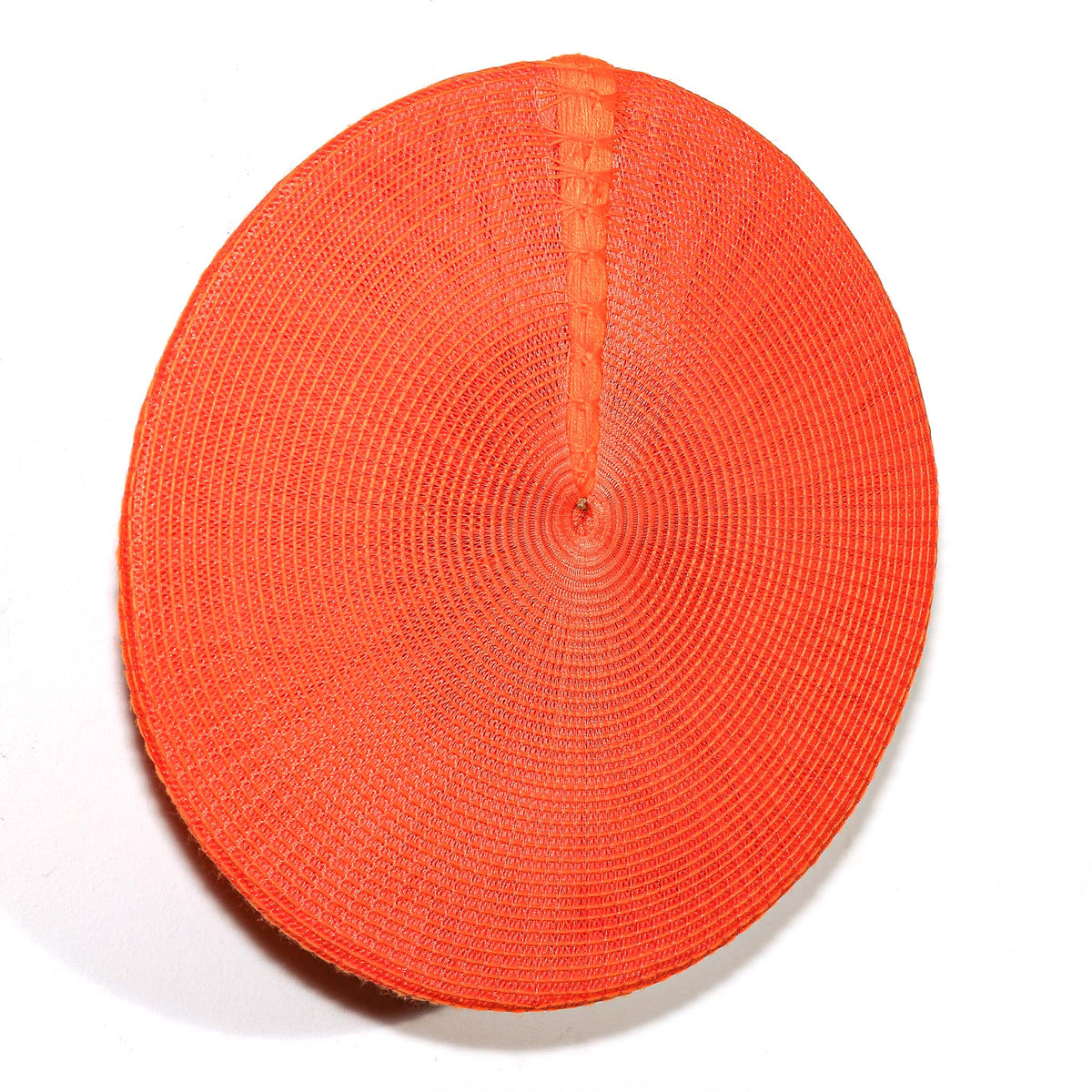 Orange South African Zulu hat used as sculptural wall art, adding vivid color and texture to an interior
