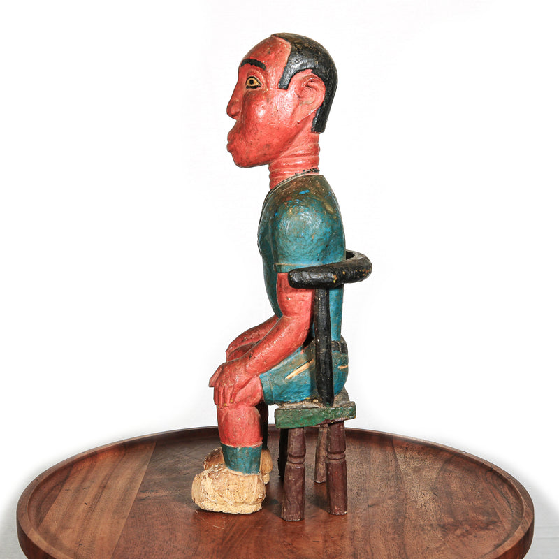 Colonial African figure on stool statue