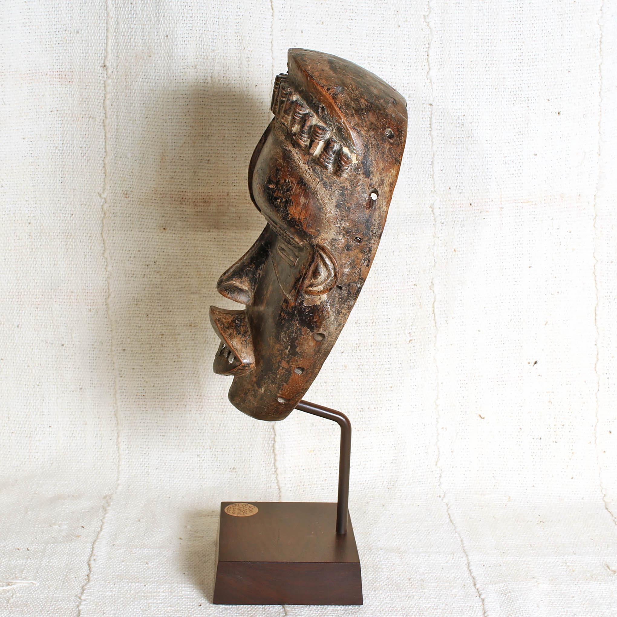 Bassa Mask from Liberia on a stand showing side 